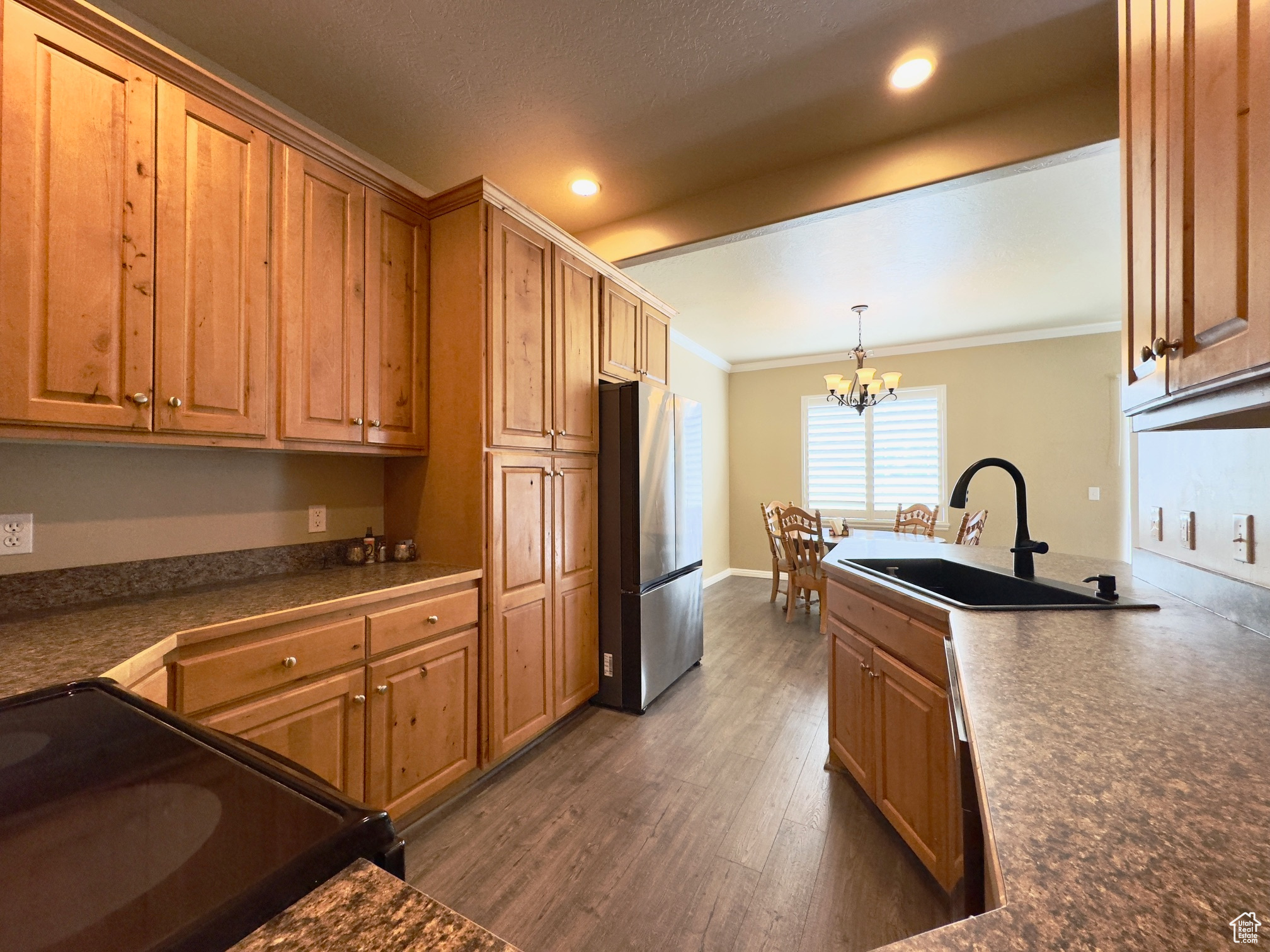 Kitchen featuring lots of cabinets, black range with electric stovetop, stainless steel fridge, new dark hardwood flooring