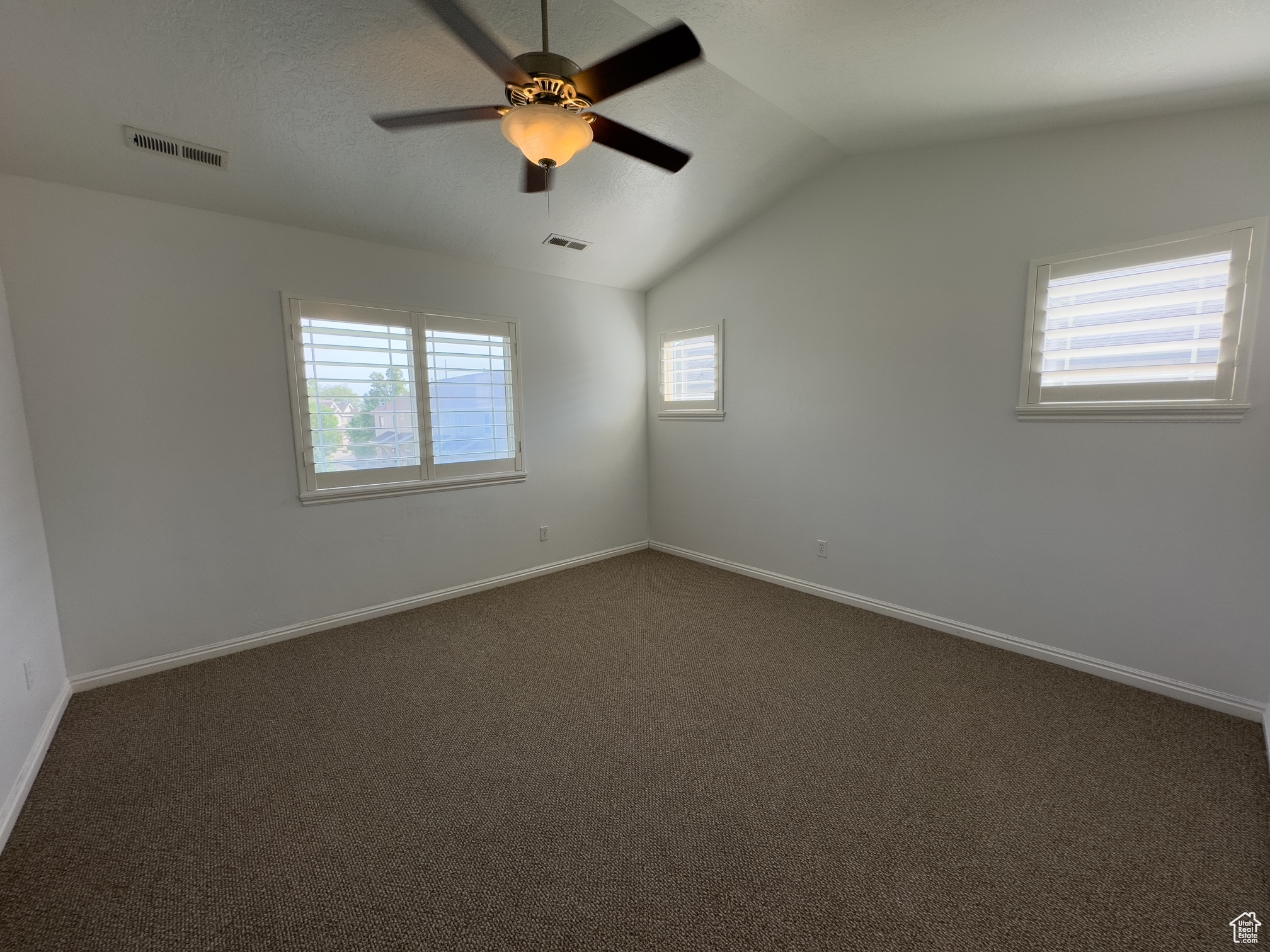 Master bedroom with vaulted ceiling, fan & plantation shutters