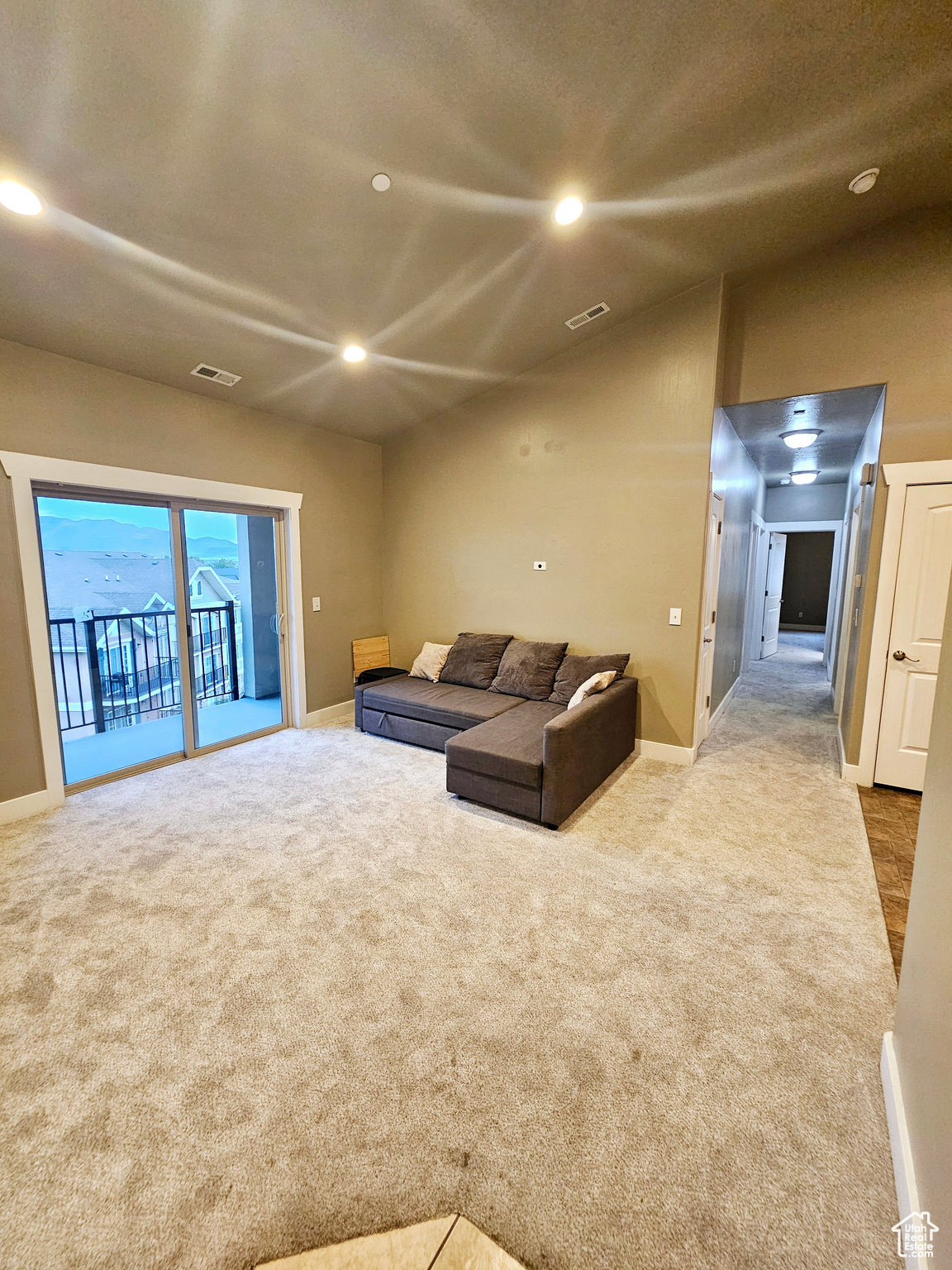 Carpeted living room with vaulted ceiling