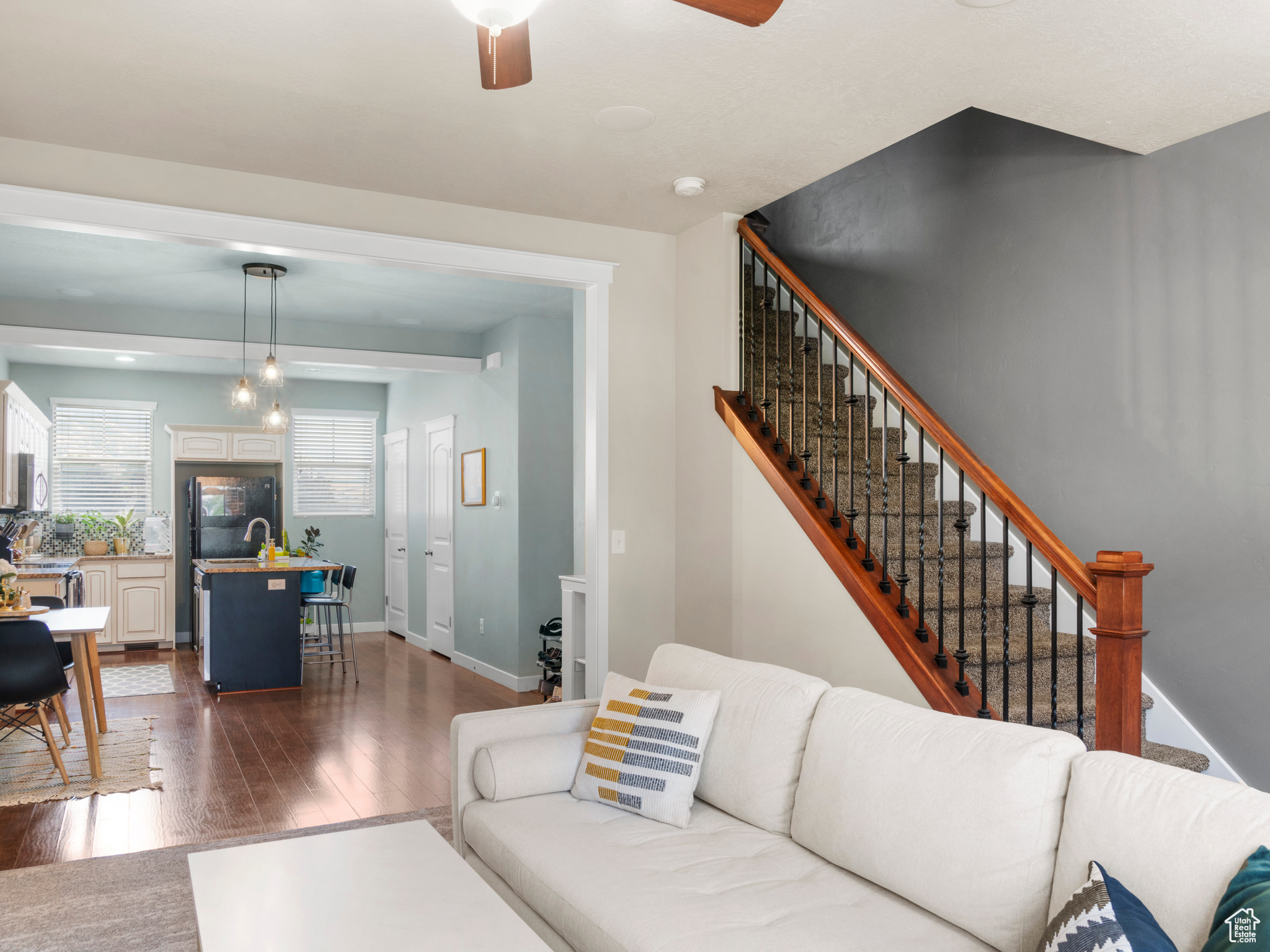 Living room featuring dark wood-type flooring and ceiling fan