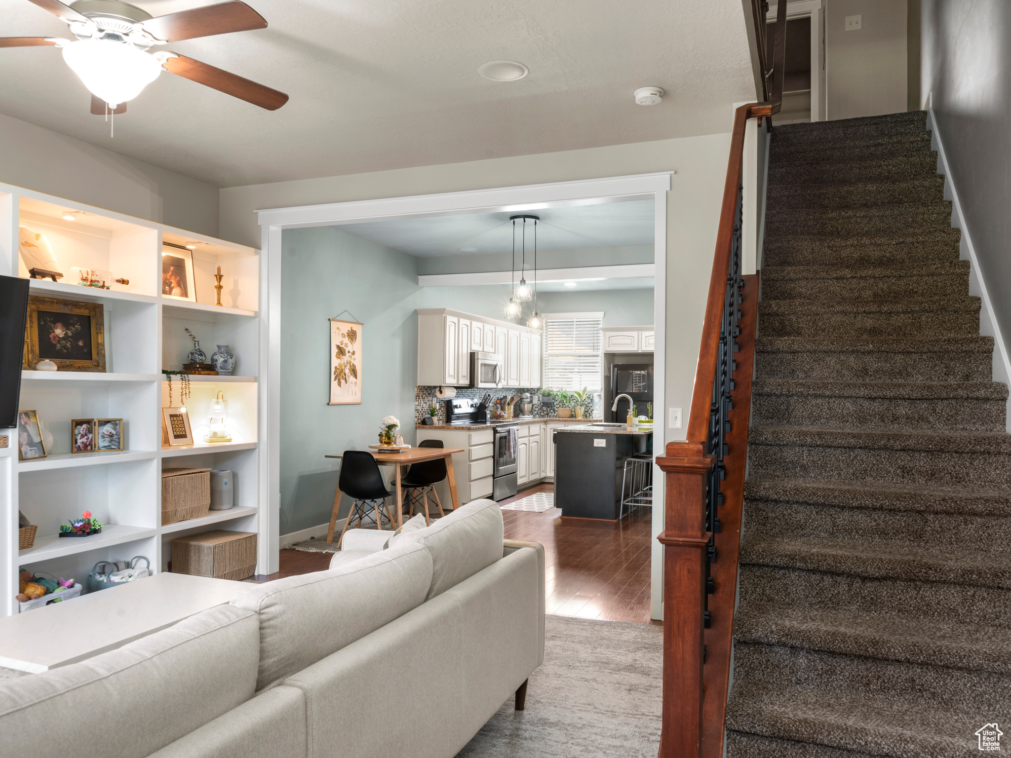 Living room with ceiling fan, sink, and hardwood / wood-style floors