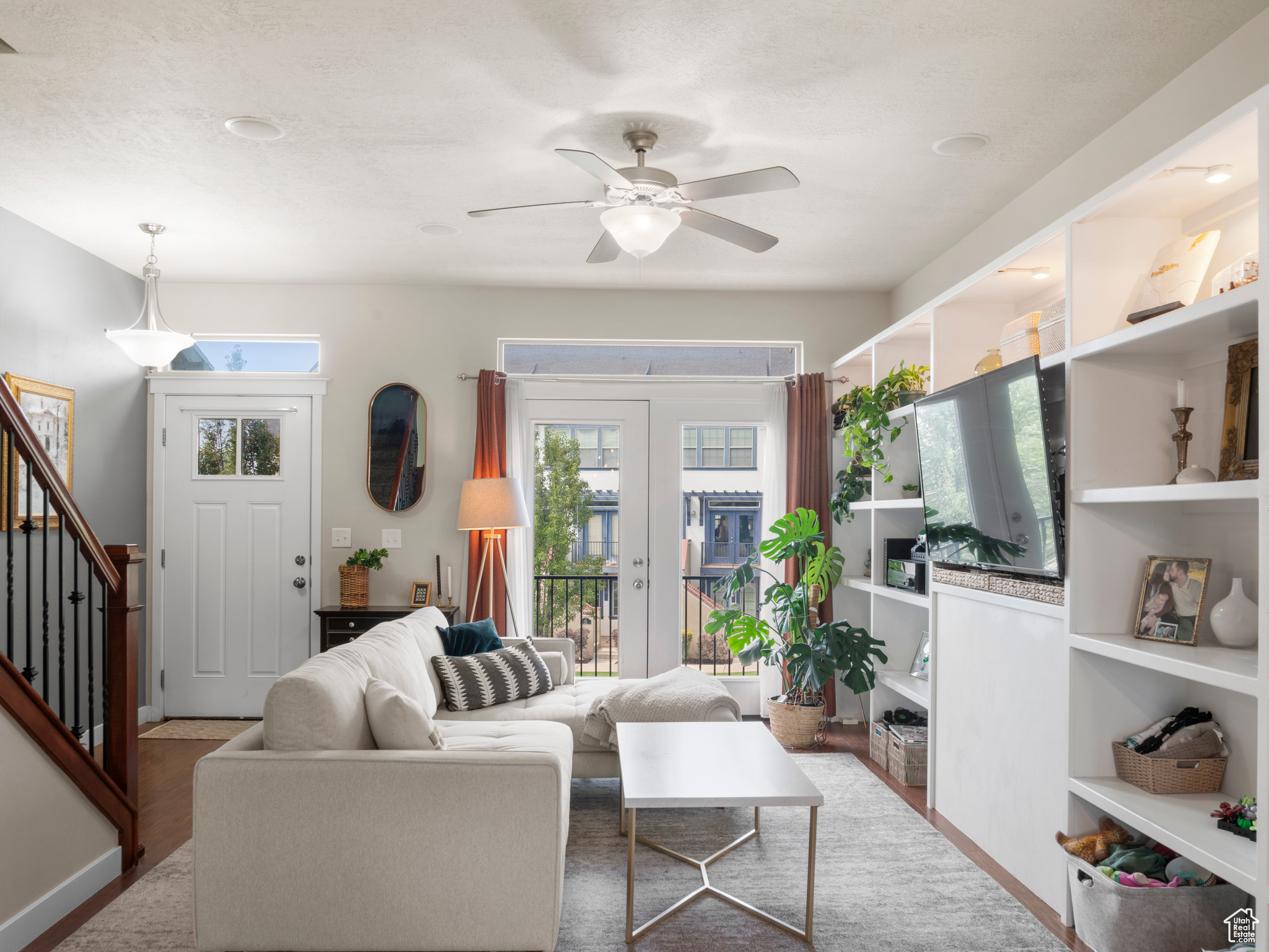 Living room featuring french doors, a textured ceiling, wood-type flooring, and ceiling fan