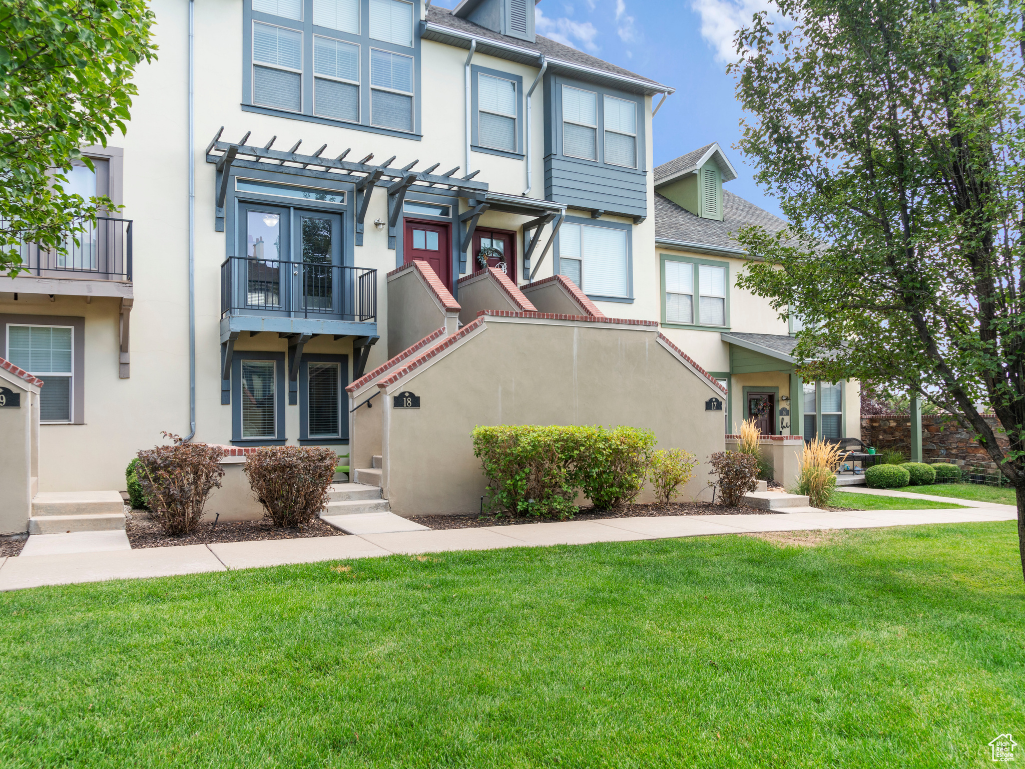 View of front of house with a balcony and a front lawn