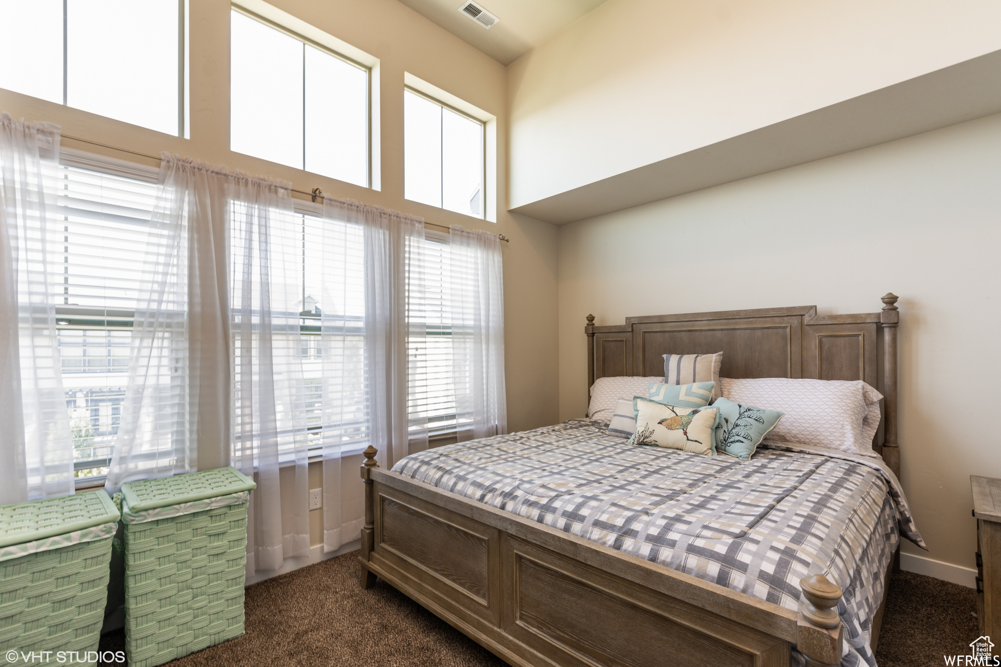 Primary Bedroom- featuring a towering ceiling, multiple windows