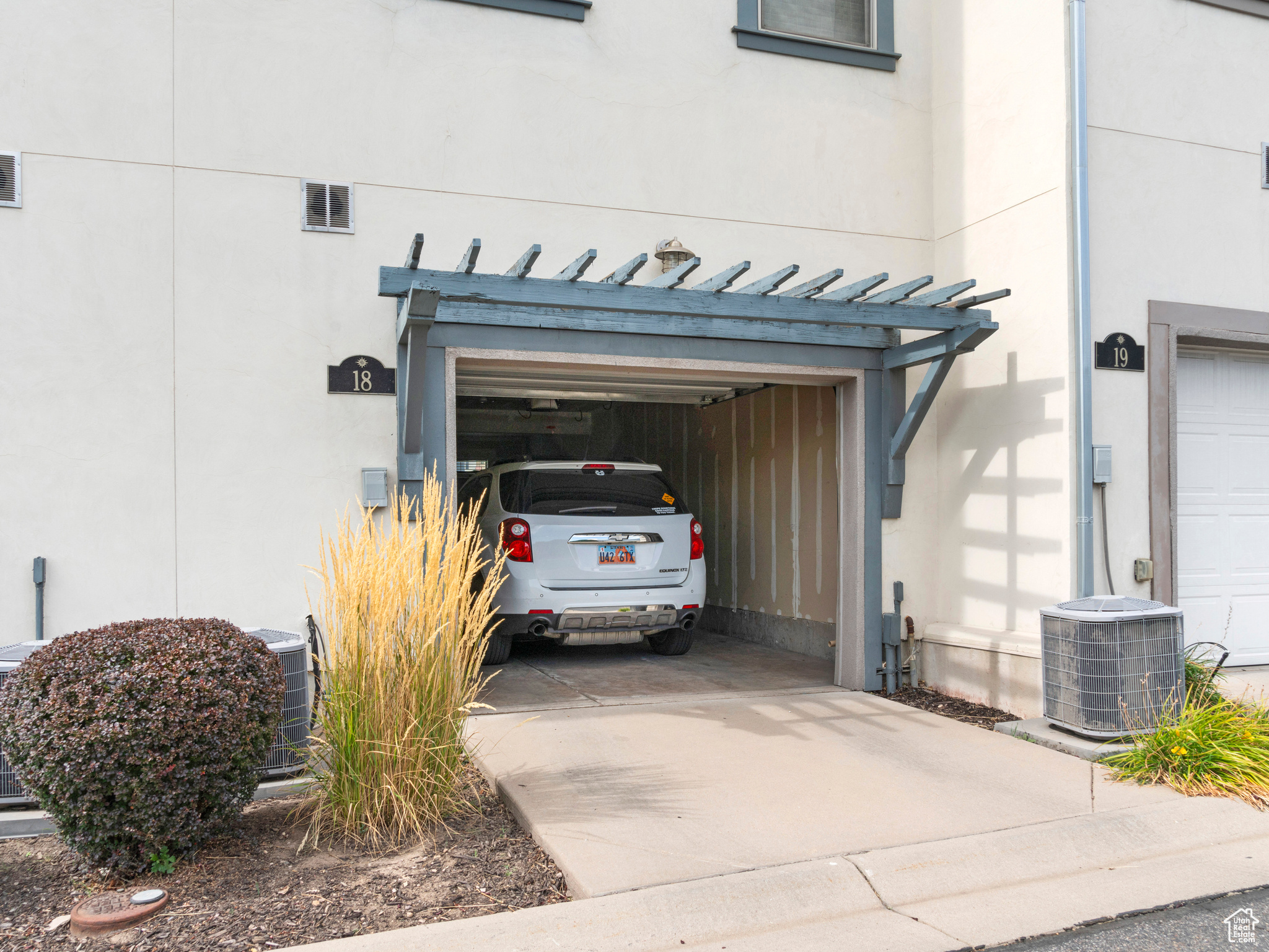 Garage featuring central AC unit and a carport