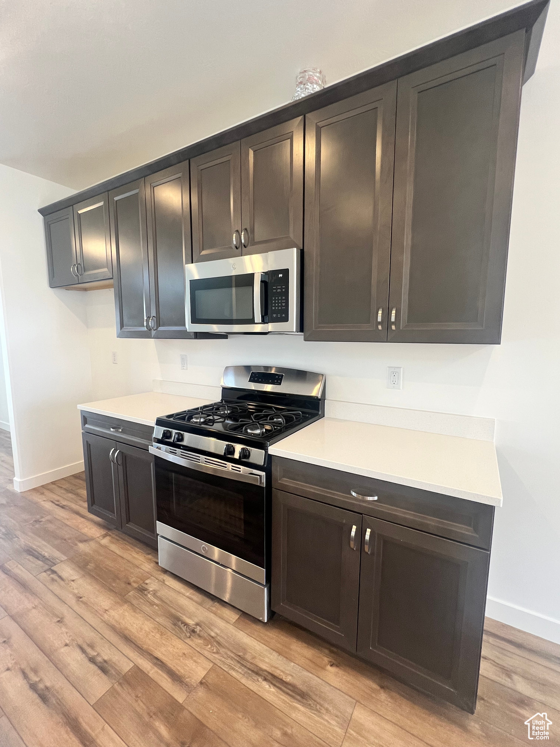 Kitchen with light hardwood / wood-style flooring and appliances with stainless steel finishes