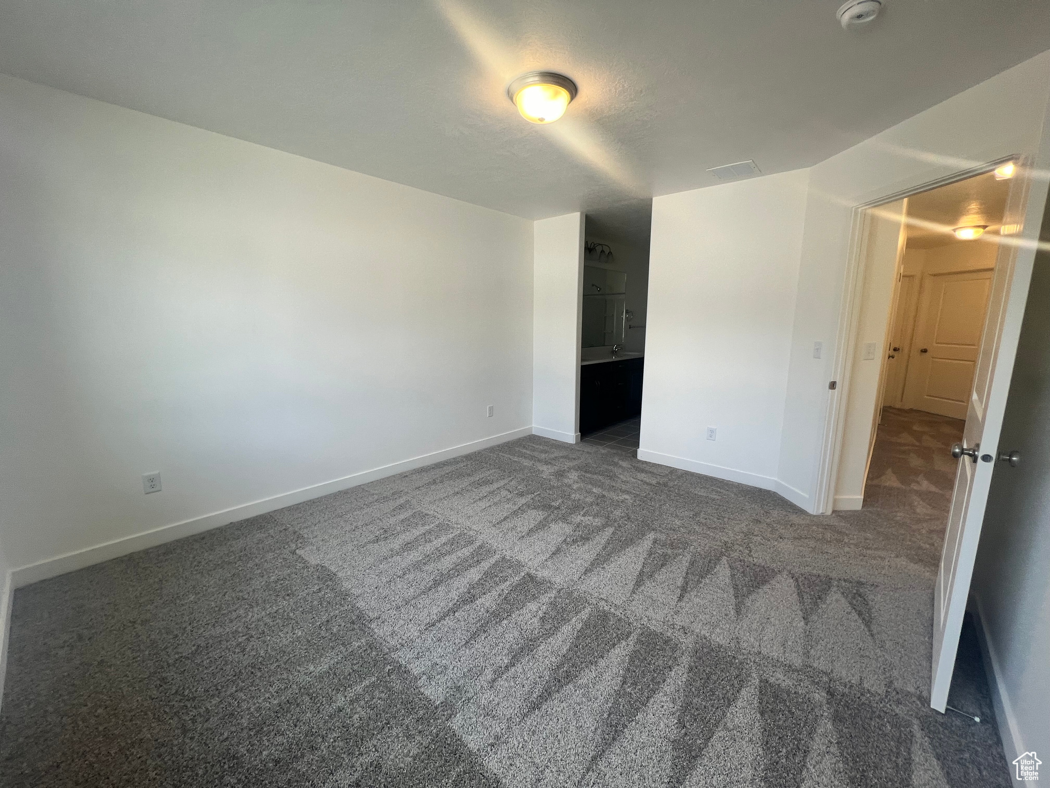 Unfurnished bedroom featuring dark colored carpet