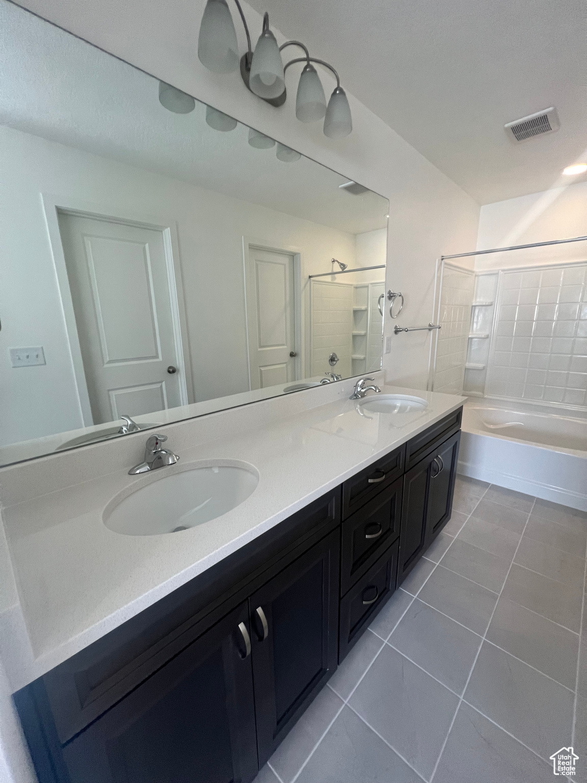 Bathroom featuring tile patterned flooring, vanity, and plus walk in shower