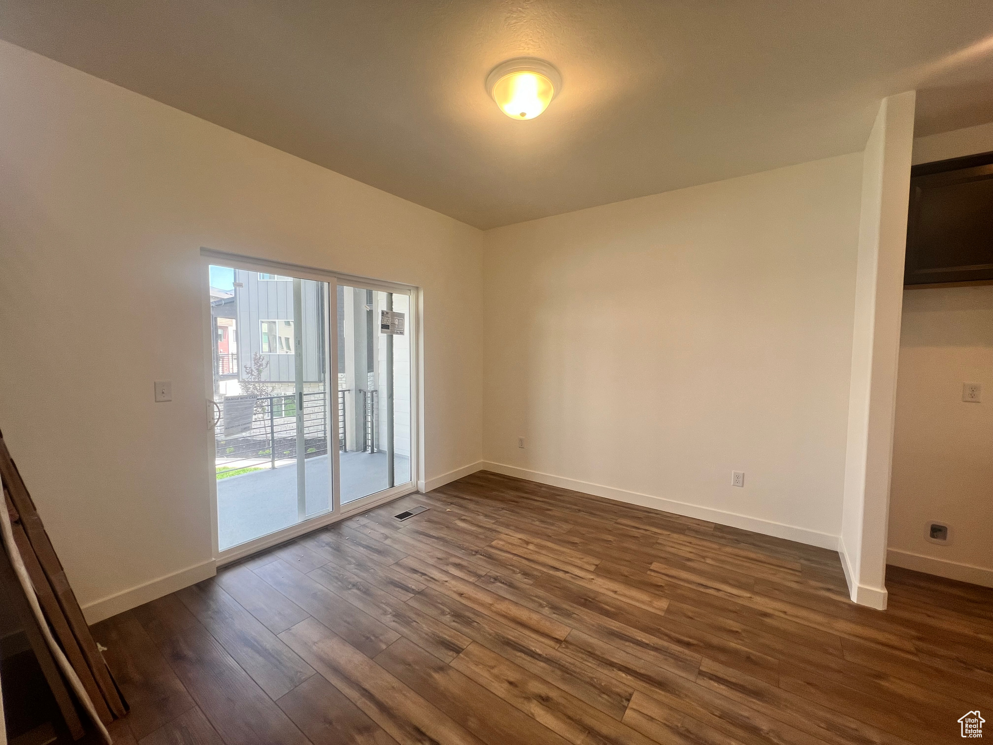 Empty room with dark hardwood / wood-style floors