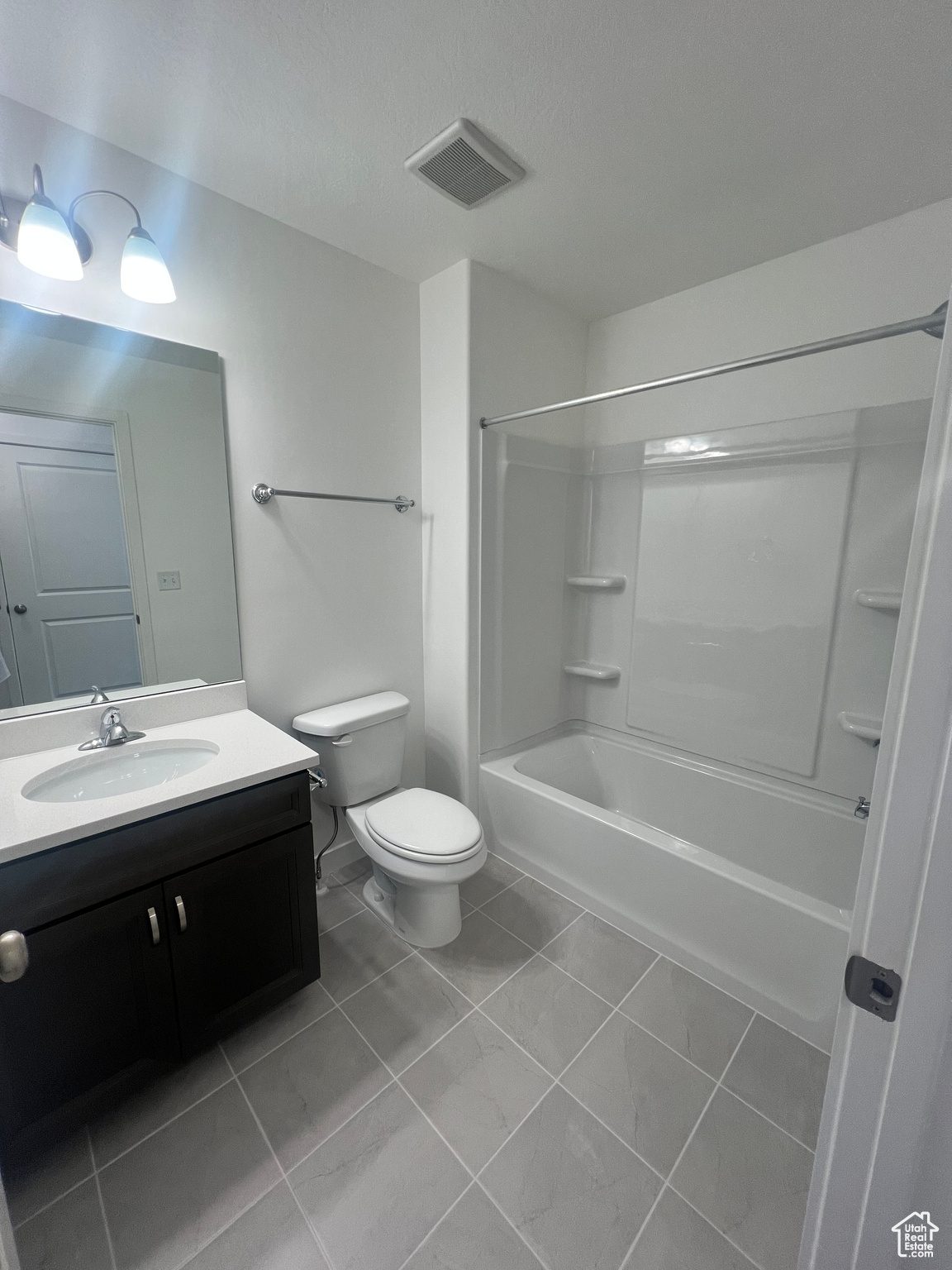 Full bathroom with tile patterned flooring, vanity, toilet, and shower / bathtub combination