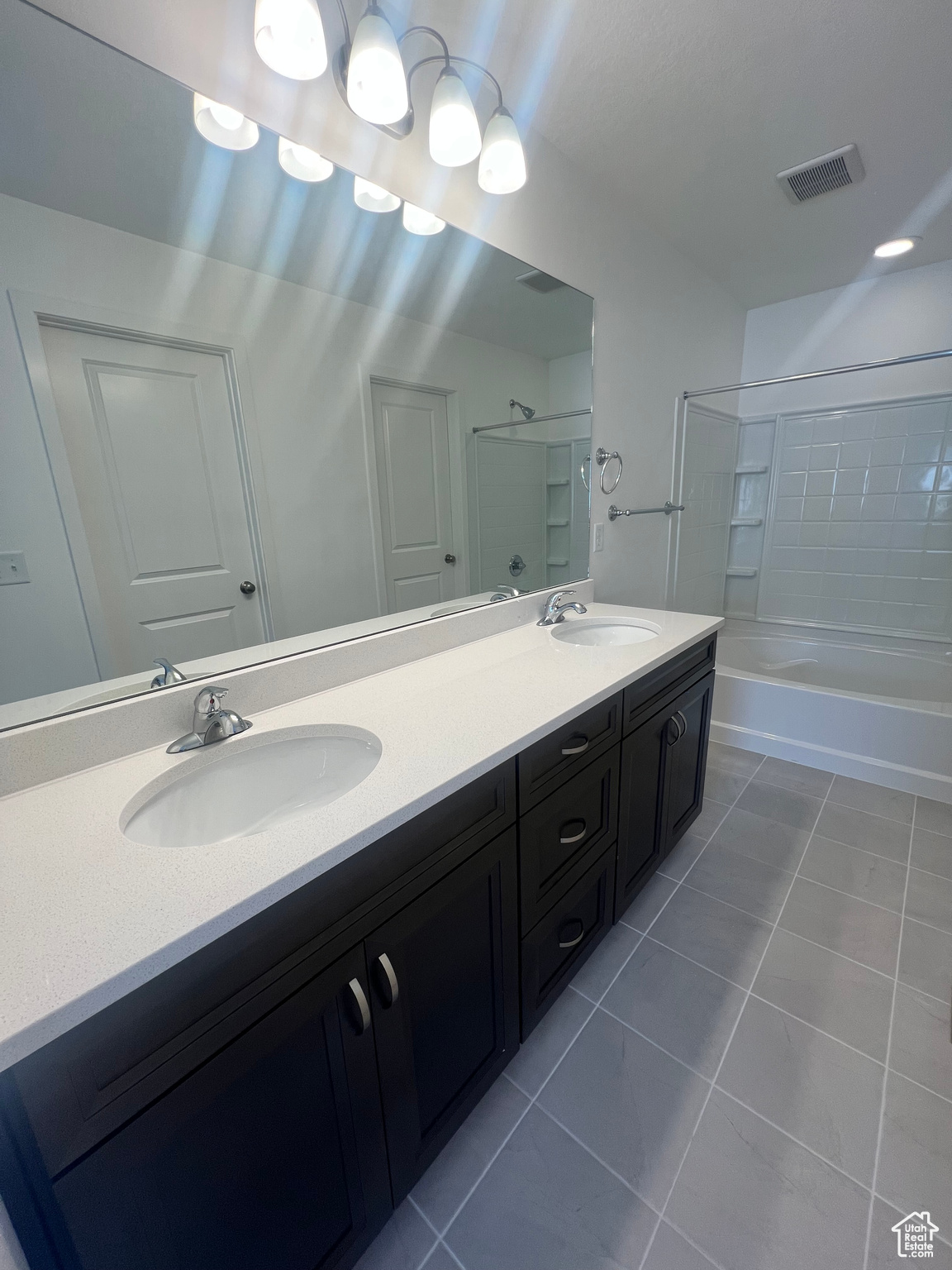 Bathroom with vanity, shower / tub combination, and tile patterned floors