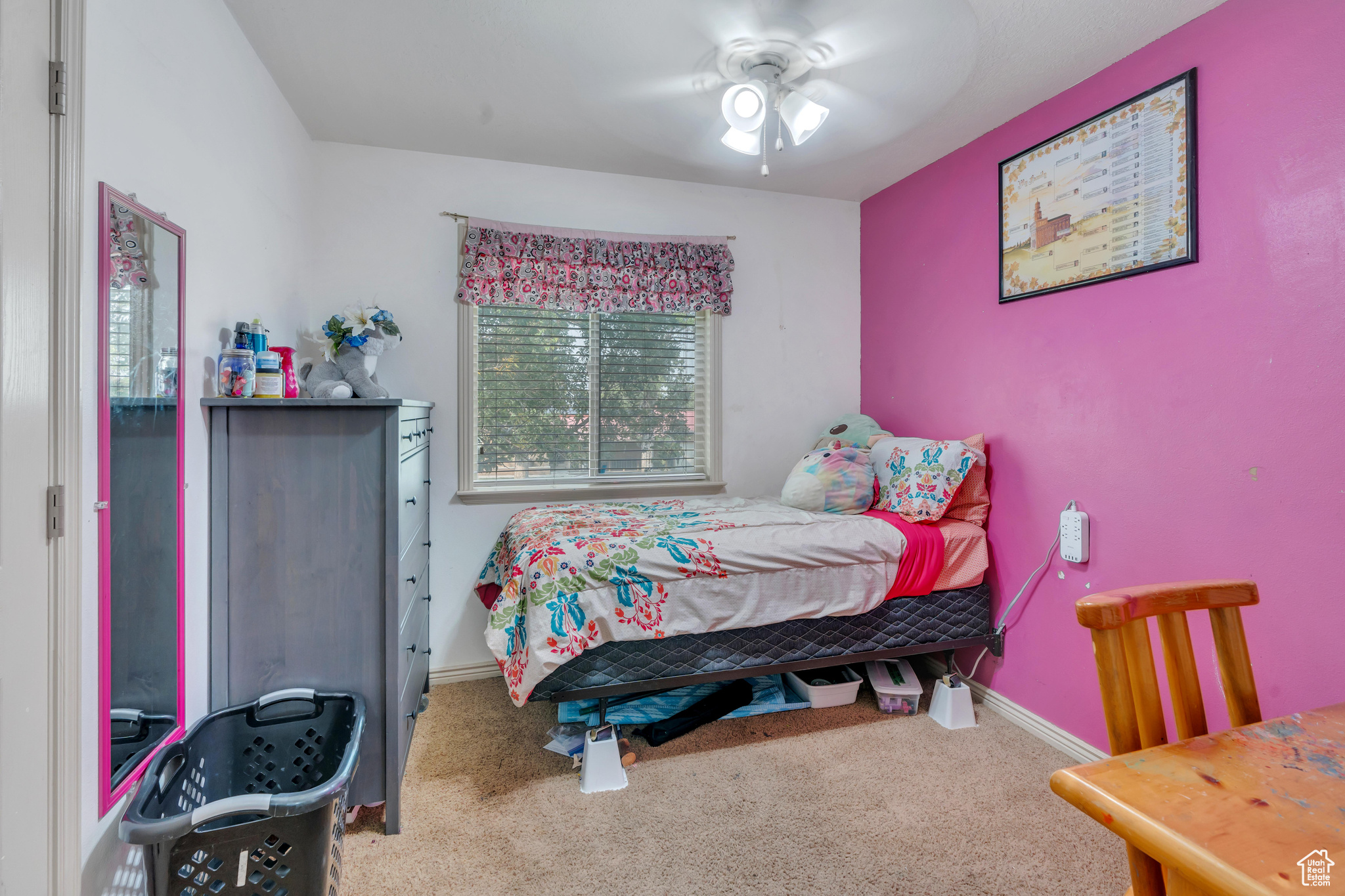 Carpeted bedroom with ceiling fan and multiple windows