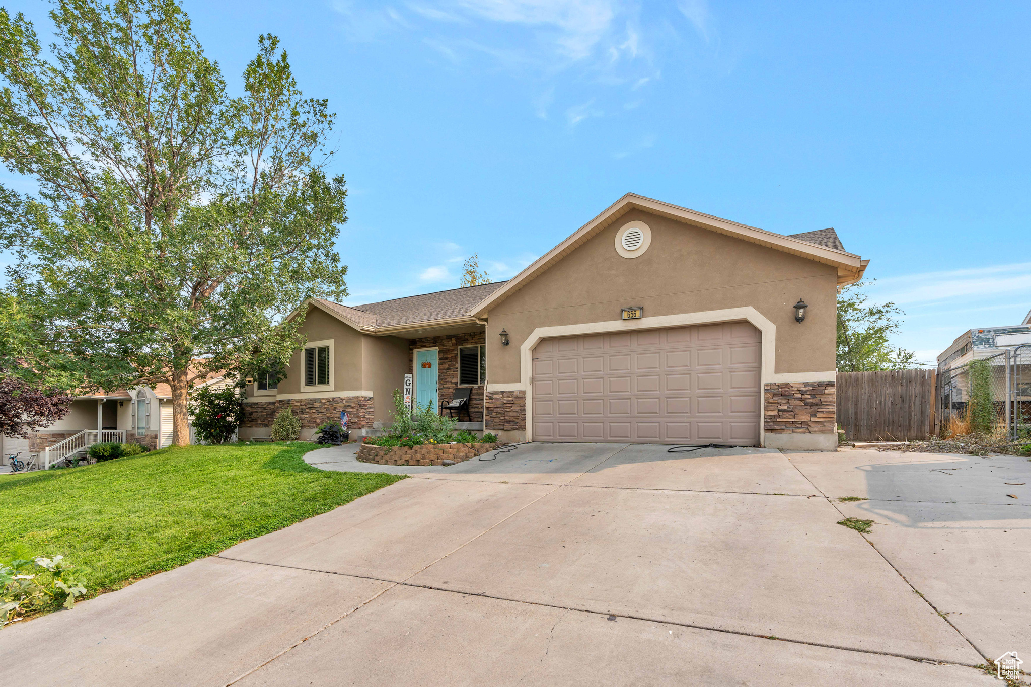 View of front of property with a garage and a front lawn