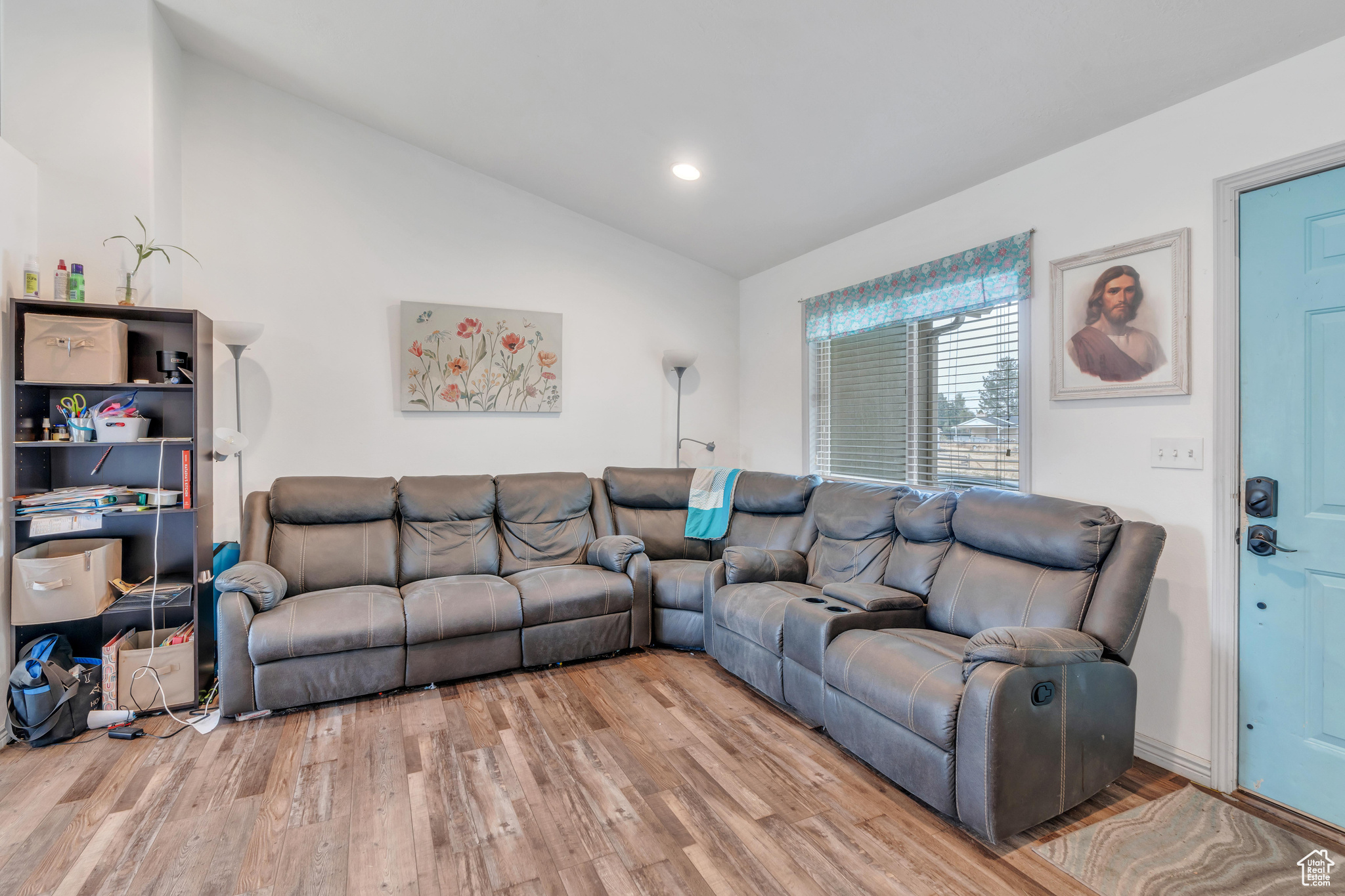 Living room with lofted ceiling and light hardwood / wood-style flooring