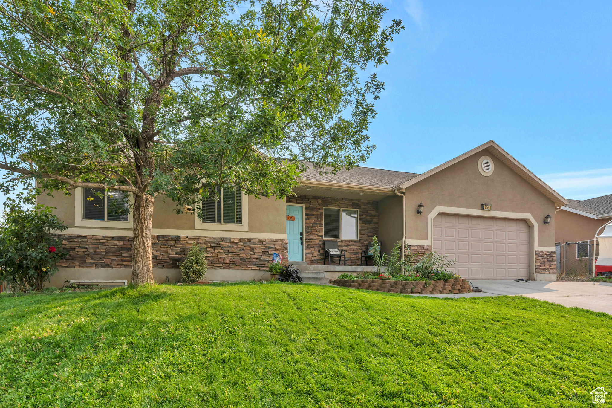 View of front facade featuring a garage and a front yard