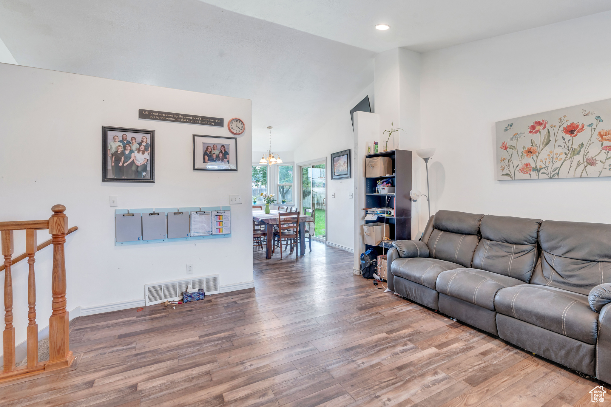 Living room featuring hardwood / wood-style floors, high vaulted ceiling, and an inviting chandelier