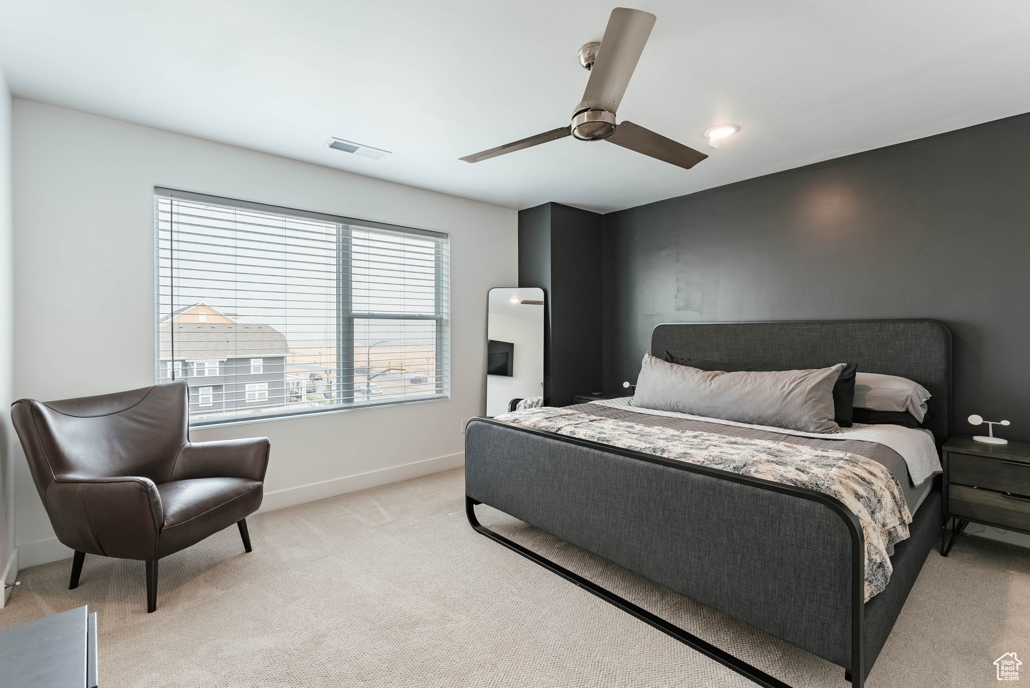 Bedroom with ceiling fan and light colored carpet