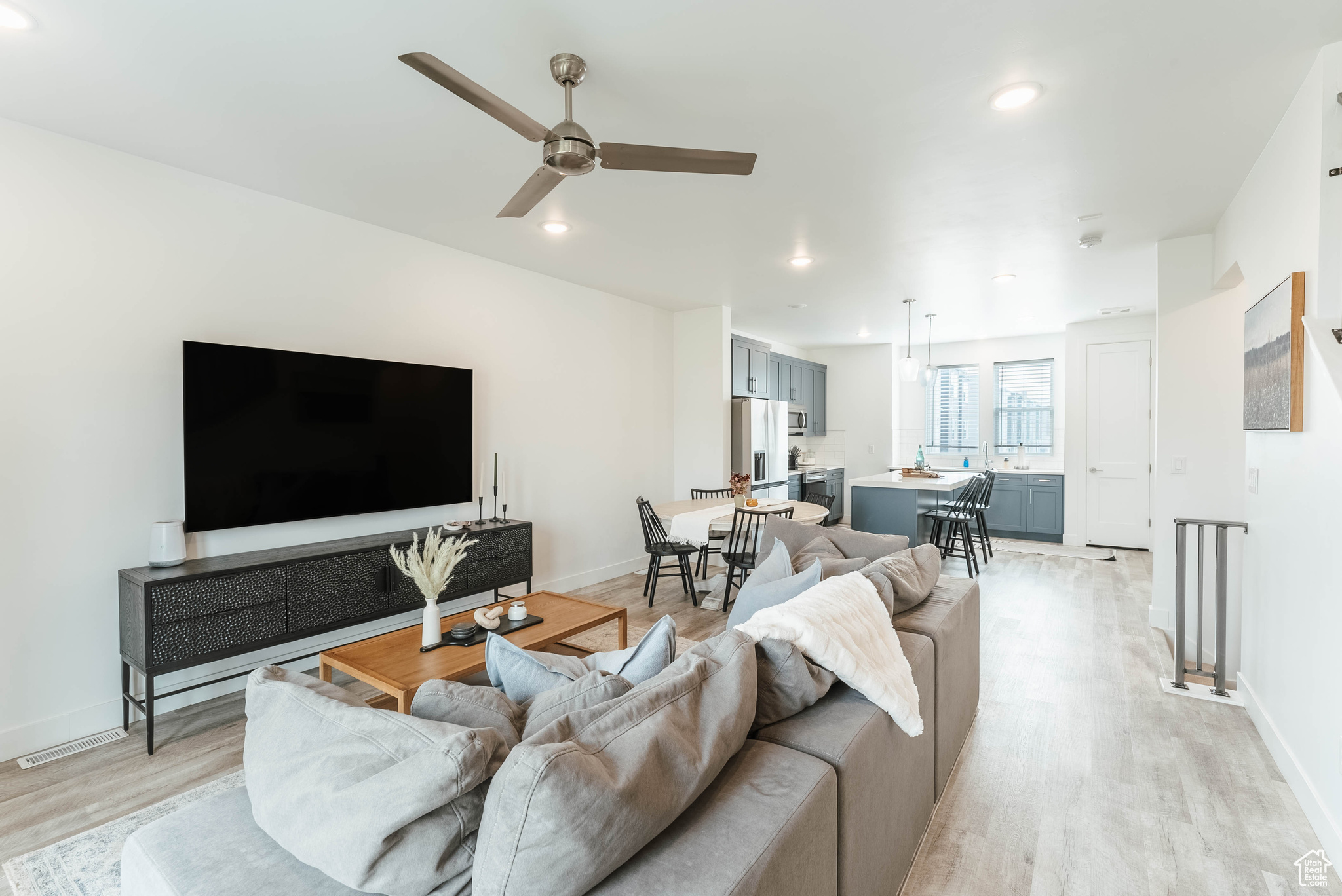 Living room with light hardwood / wood-style flooring and ceiling fan