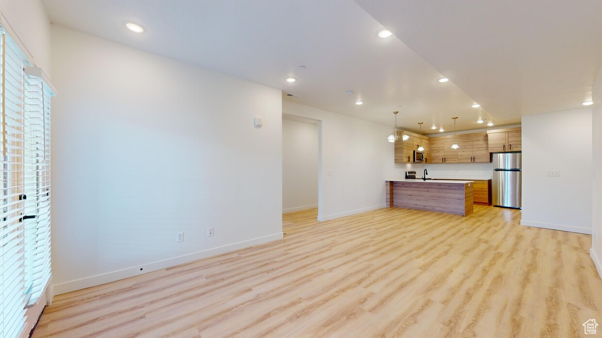 Unfurnished living room featuring light hardwood / wood-style floors and sink