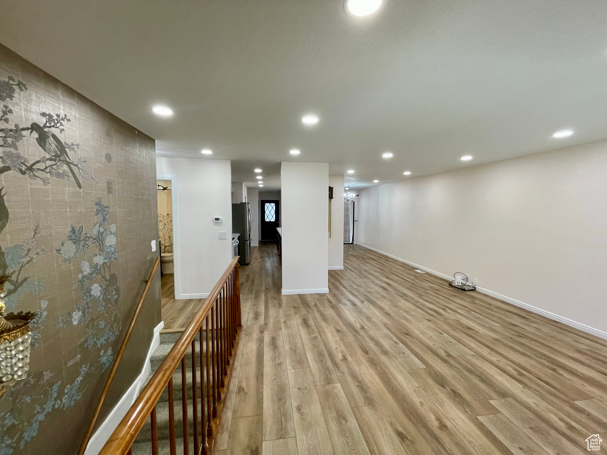 Basement featuring light wood-type flooring and stainless steel refrigerator