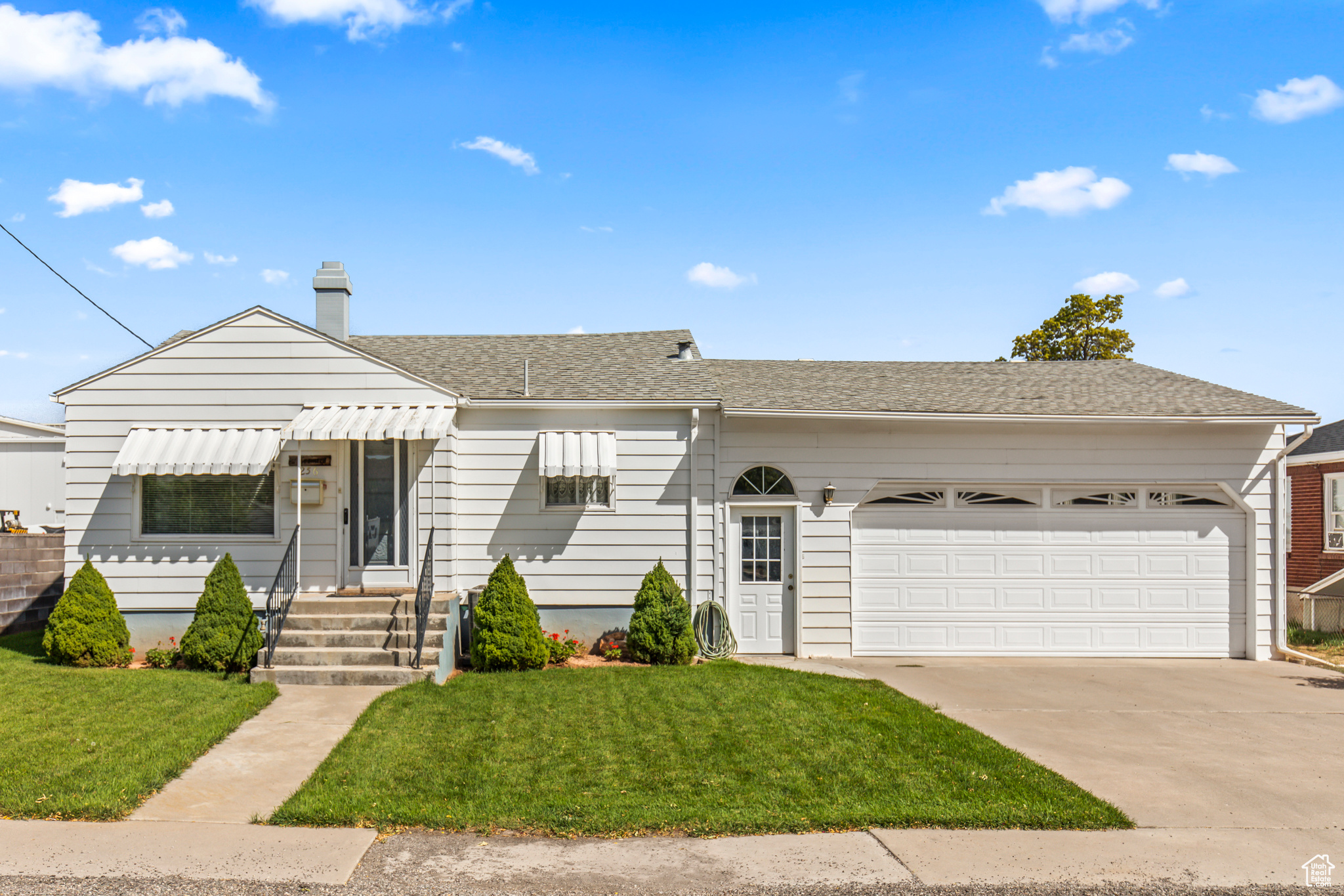 View of front of property featuring a garage and a front yard