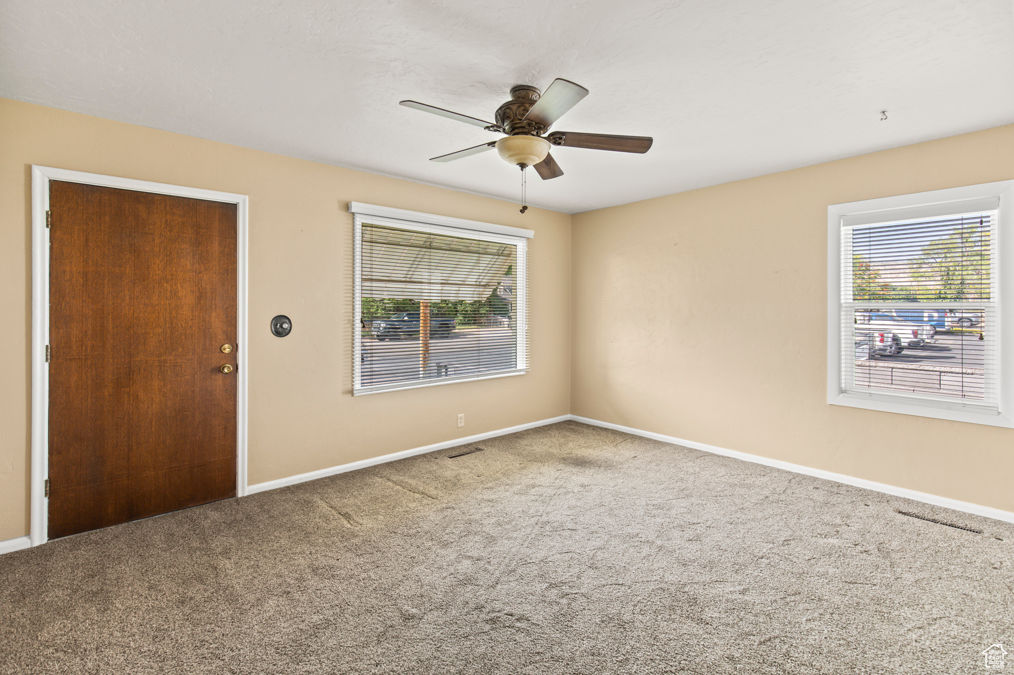 Empty room with ceiling fan and carpet flooring