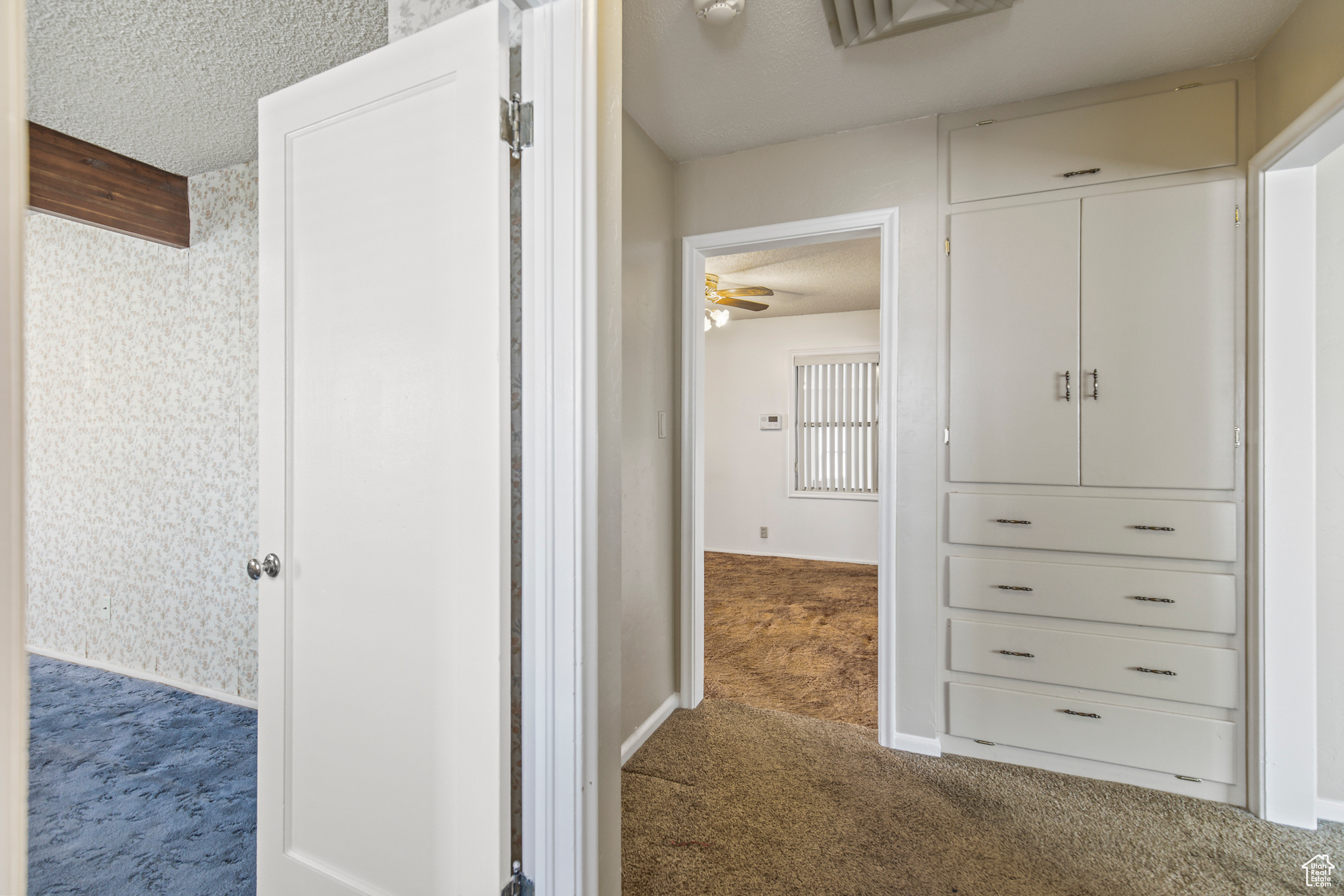 Corridor with a textured ceiling and carpet