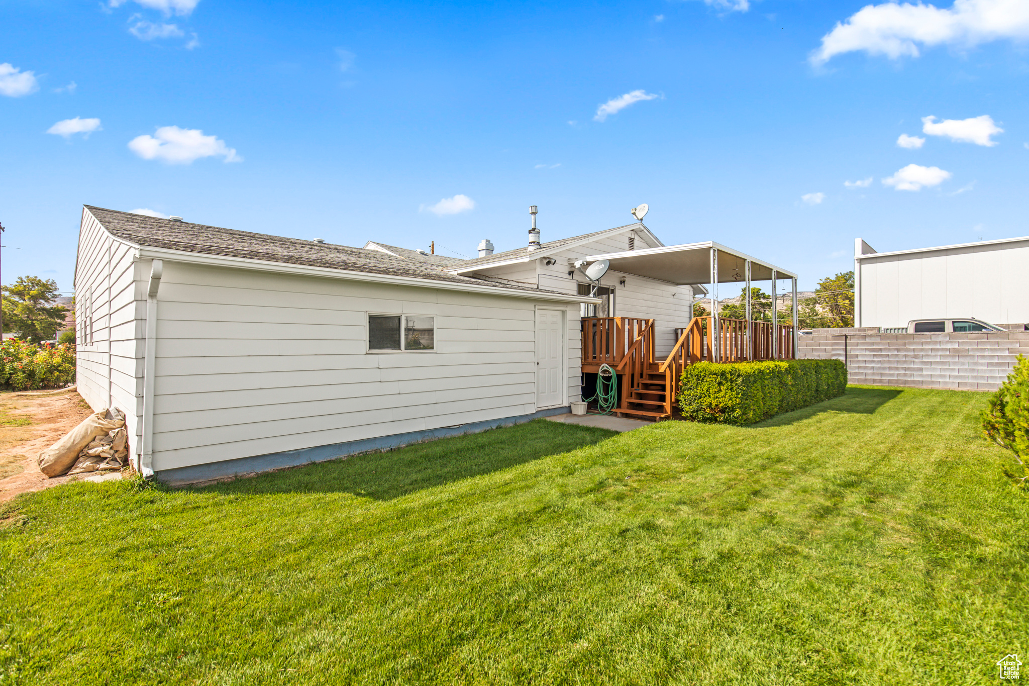 Rear view of property featuring a yard and a wooden deck