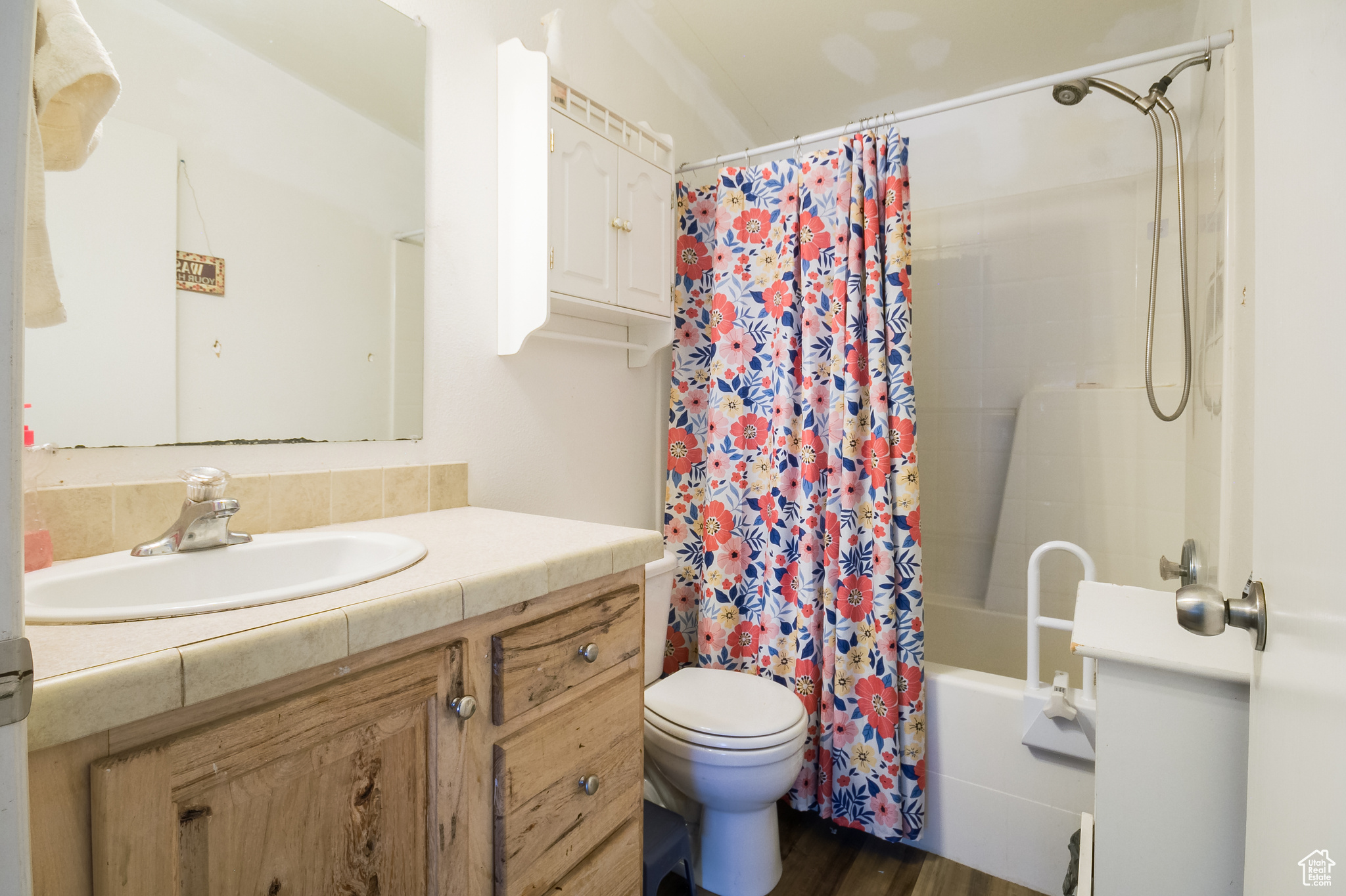 Full bathroom featuring vanity, toilet, wood-type flooring, and shower / bath combo with shower curtain