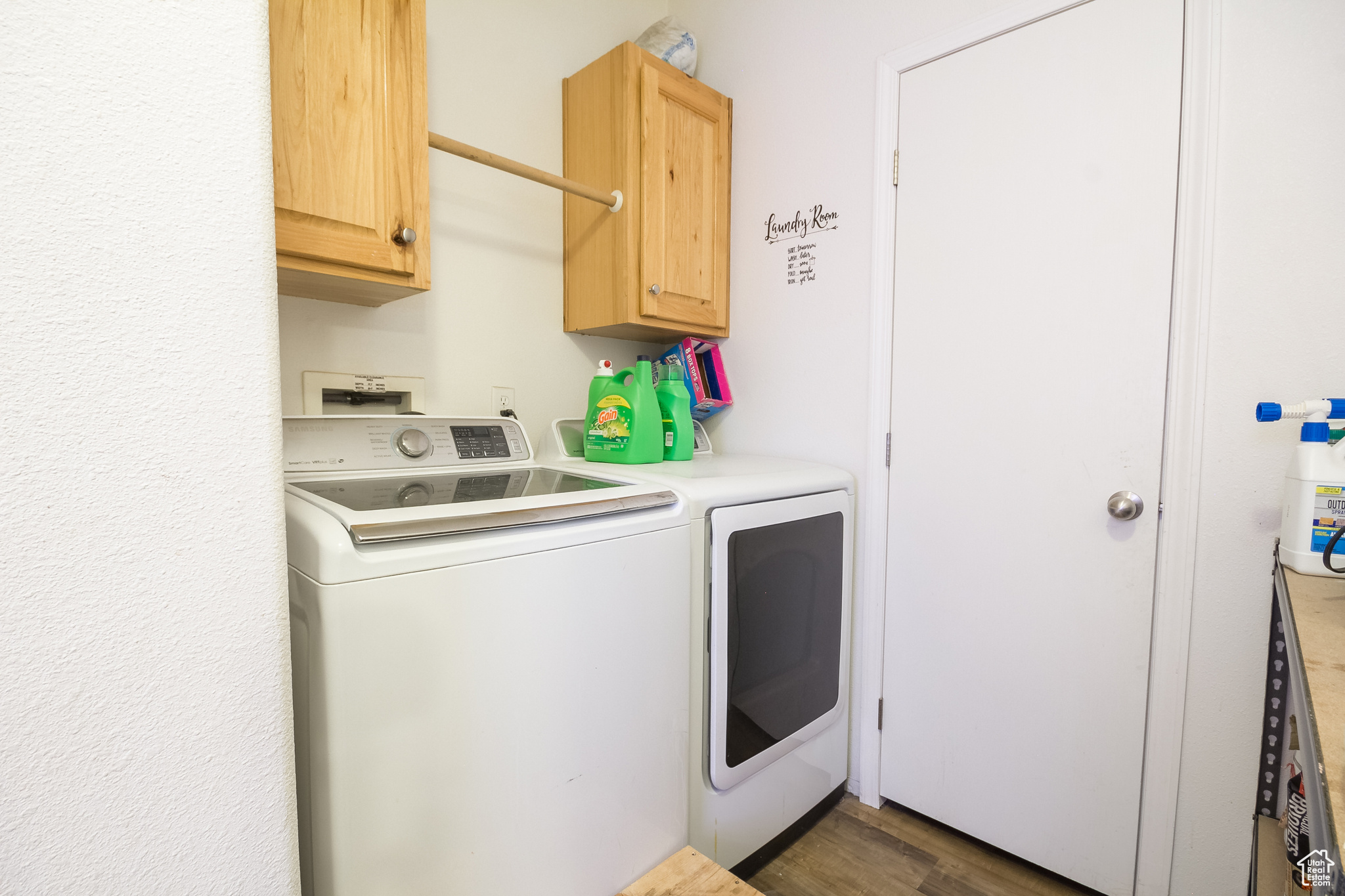 Laundry room featuring cabinets, dark wood-type flooring, and washing machine and clothes dryer