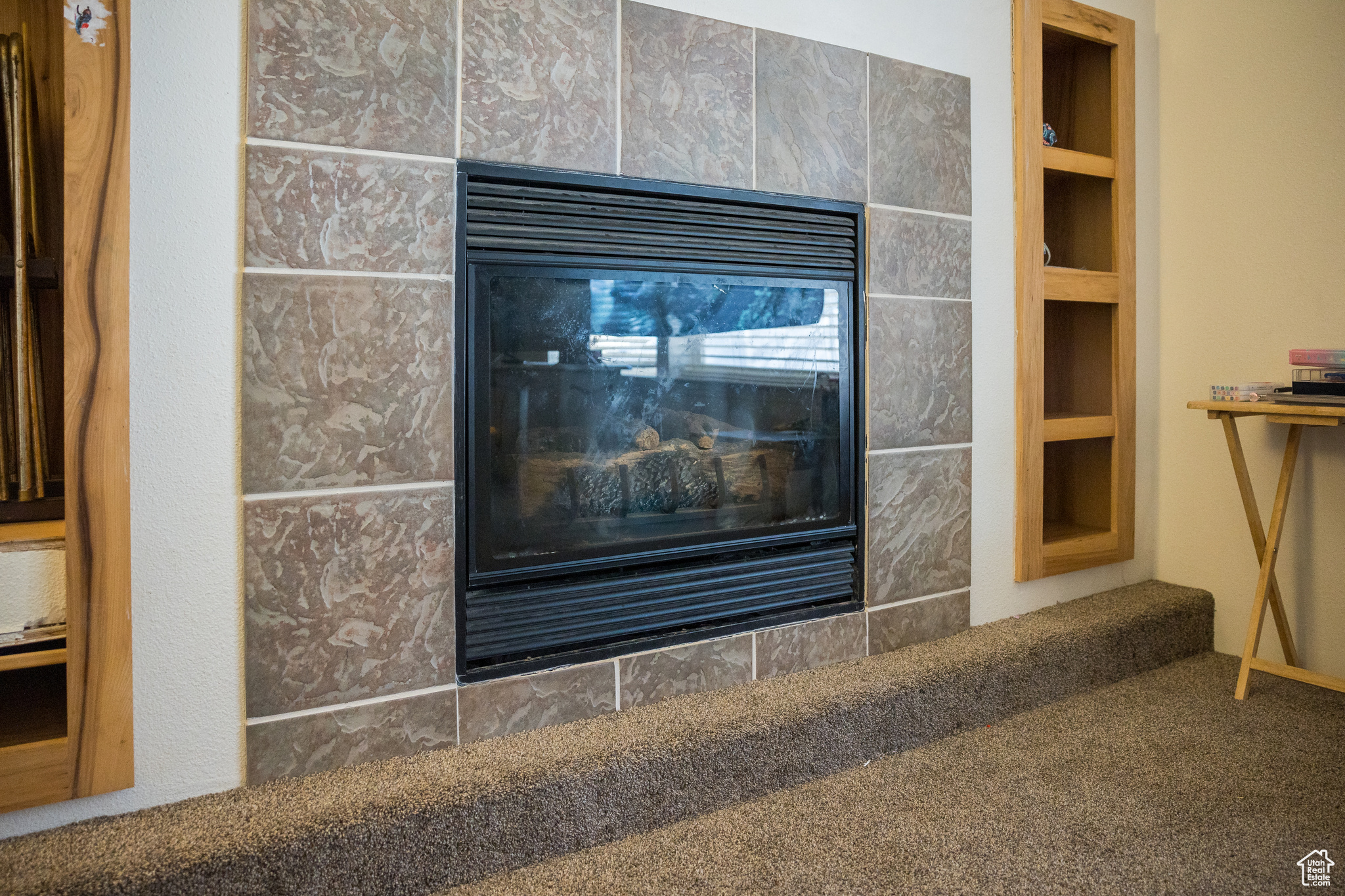 Interior details featuring carpet flooring, built in shelves, and a fireplace