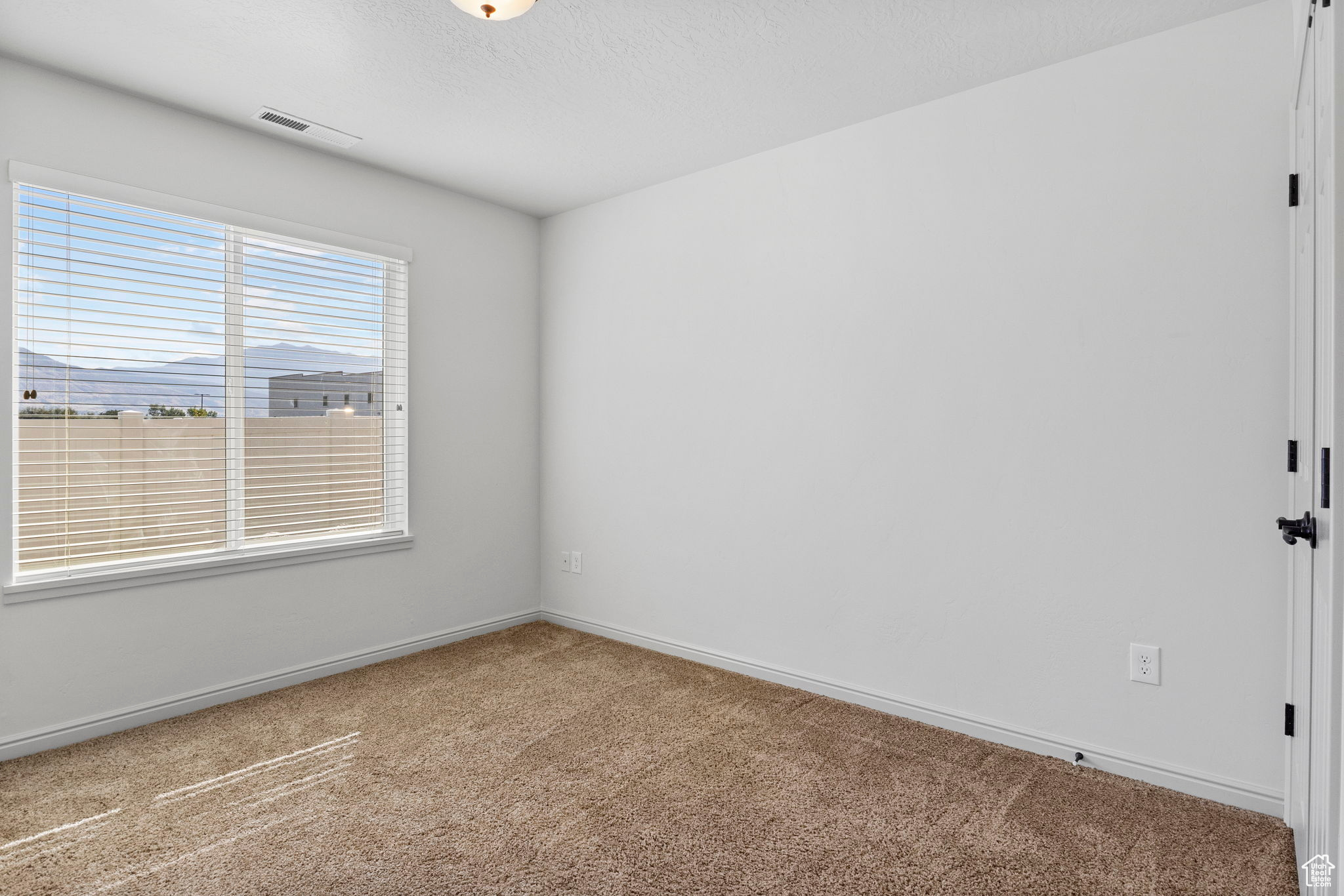 Spare room with a textured ceiling and carpet floors