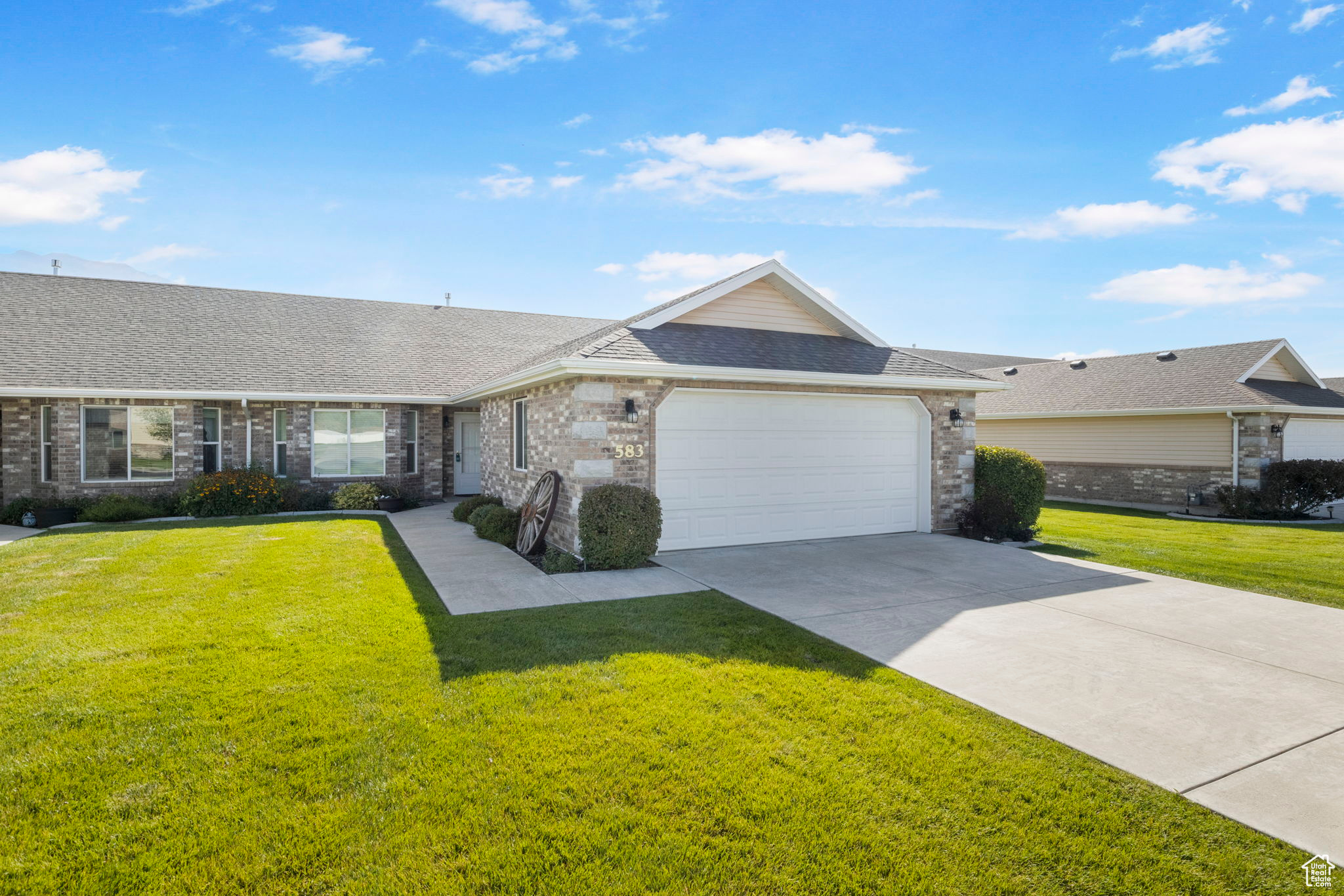 Ranch-style home featuring a garage and a front lawn