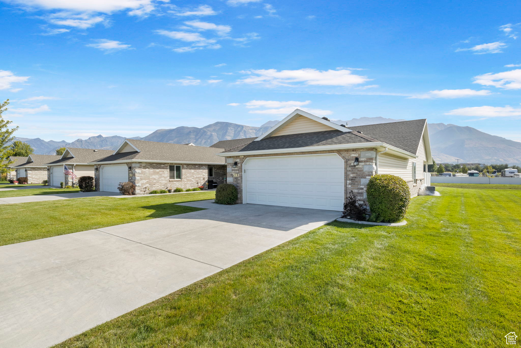 Single story home with a garage, a mountain view, and a front yard