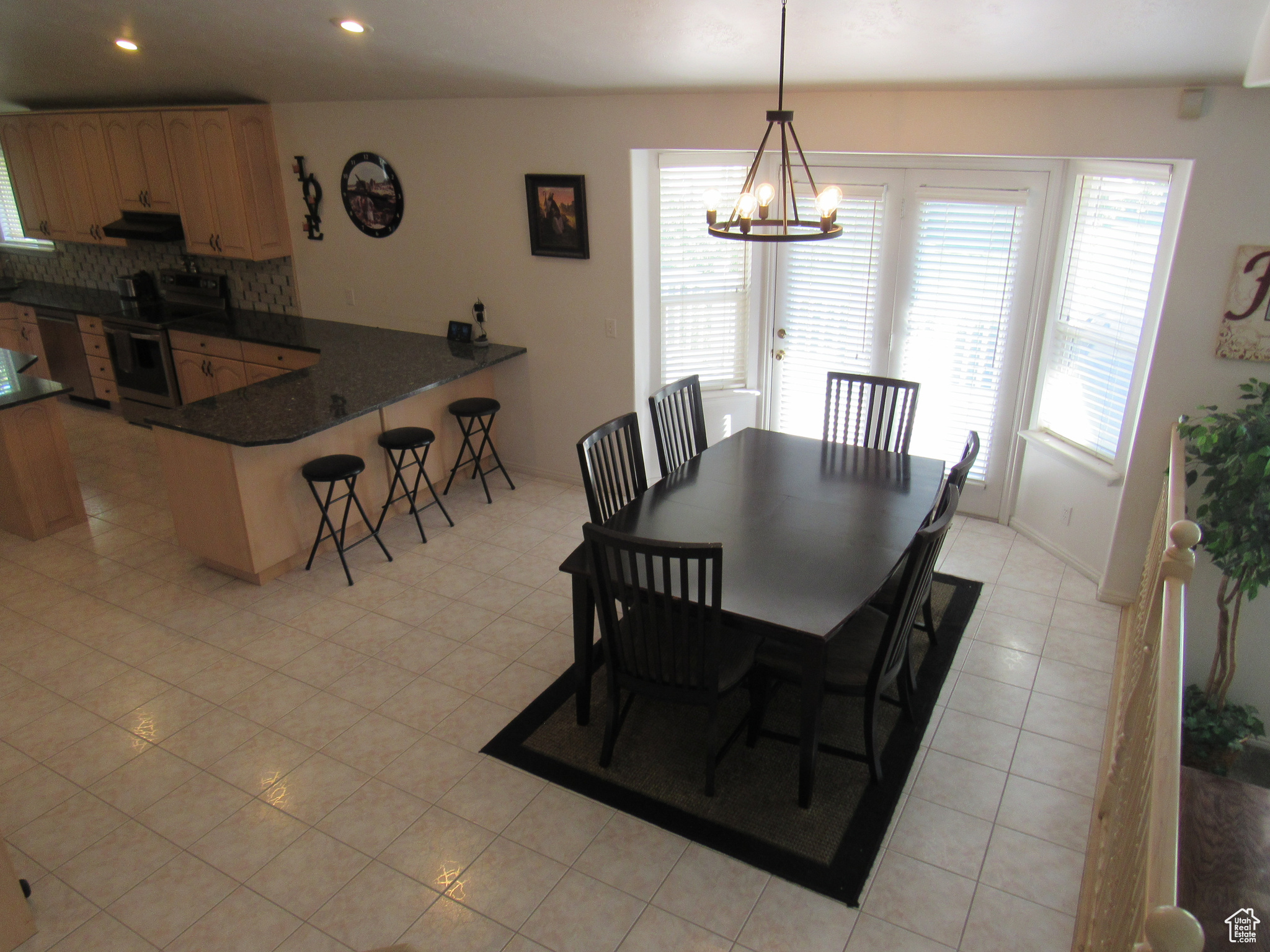 Dining room featuring light tile patterned floors and an inviting chandelier