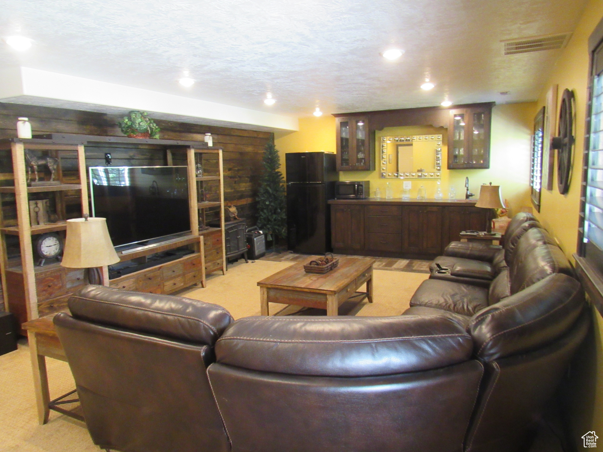 Carpeted living room with sink and a textured ceiling