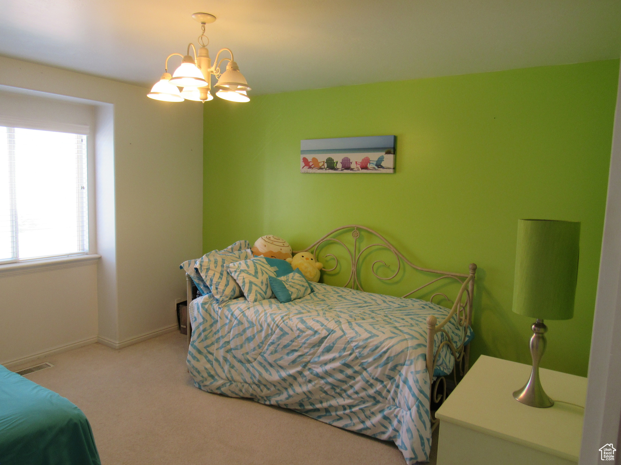 Carpeted bedroom featuring a notable chandelier