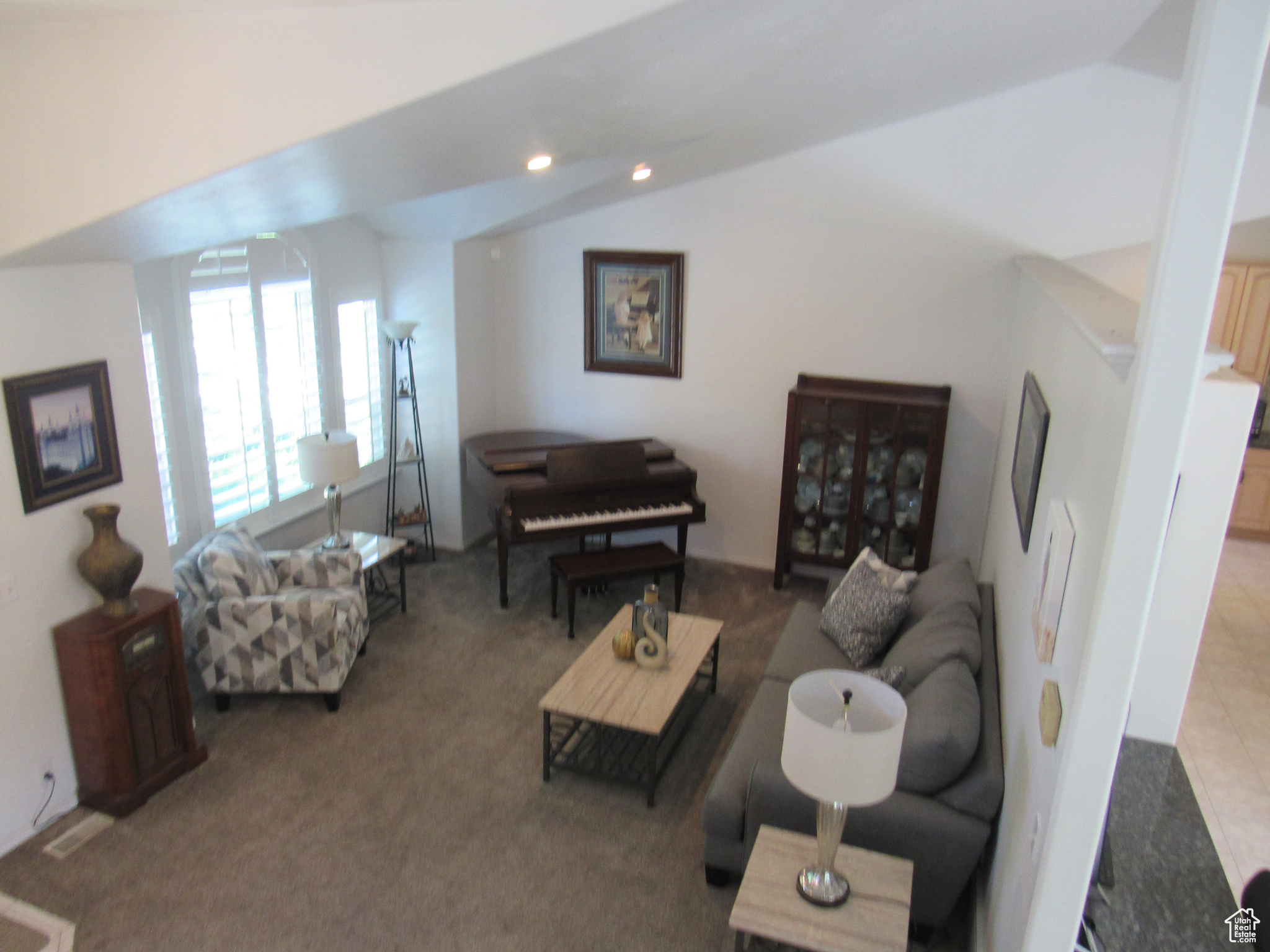 Living room featuring vaulted ceiling and light colored carpet