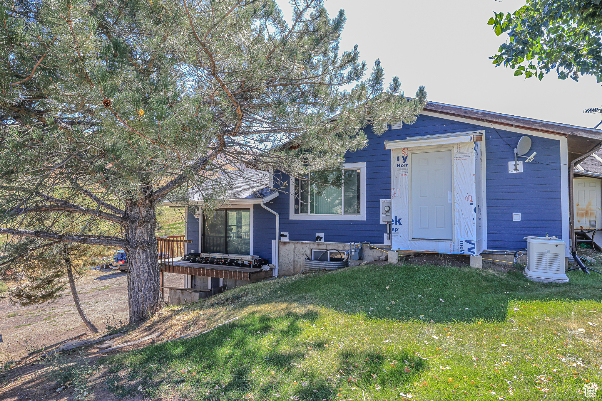 View of front of property with a wooden deck and a front yard