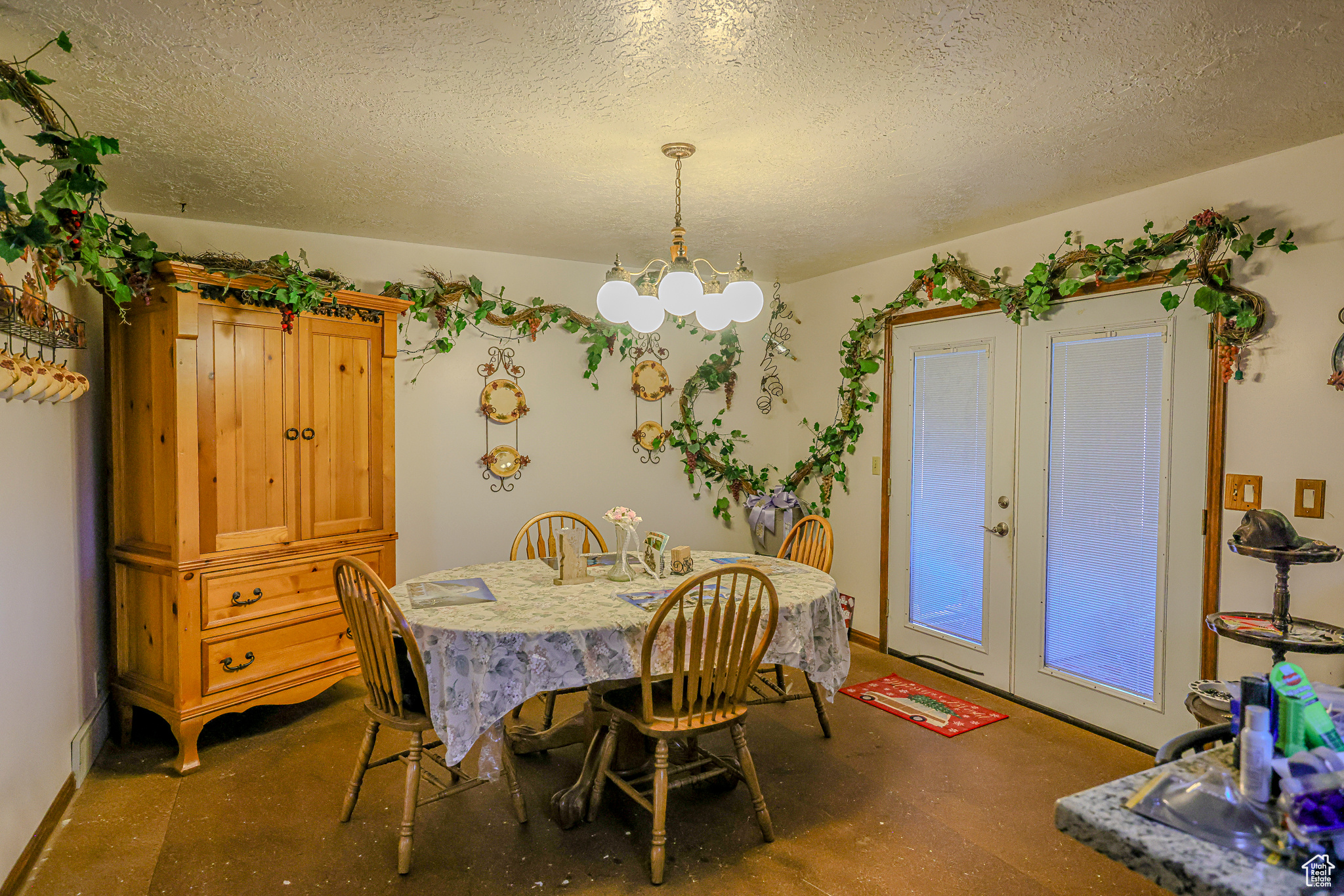 Dining room featuring a textured ceiling and an inviting chandelier