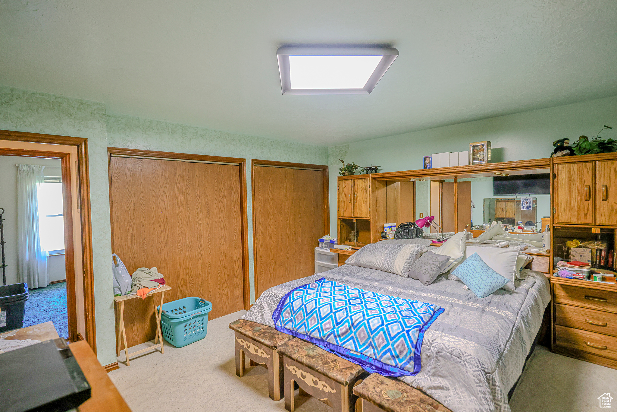 Bedroom with multiple closets and light colored carpet