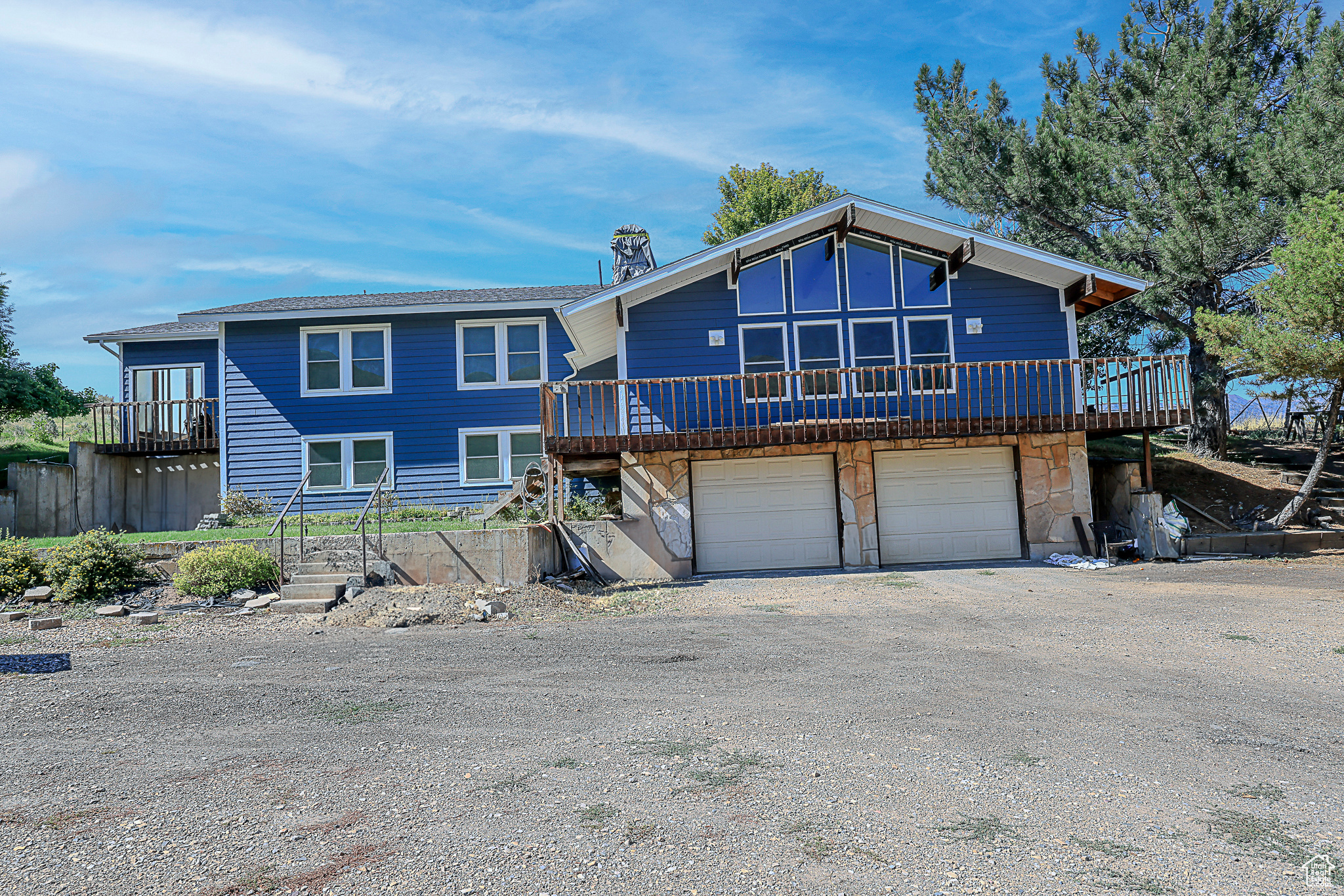 View of front of house with a garage and a deck