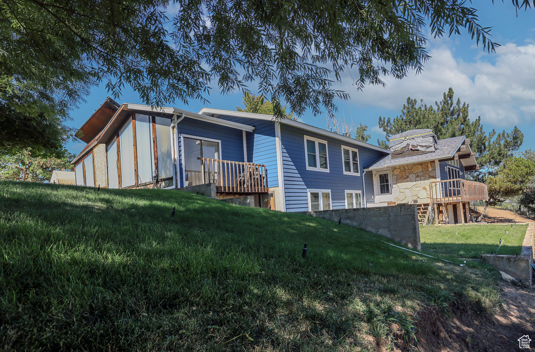 Rear view of property with a lawn and a deck