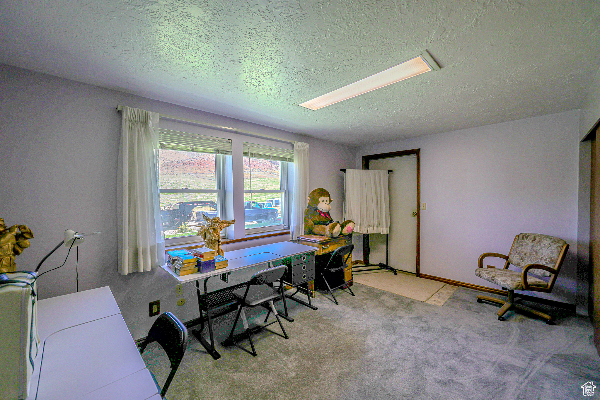 Carpeted home office with a textured ceiling