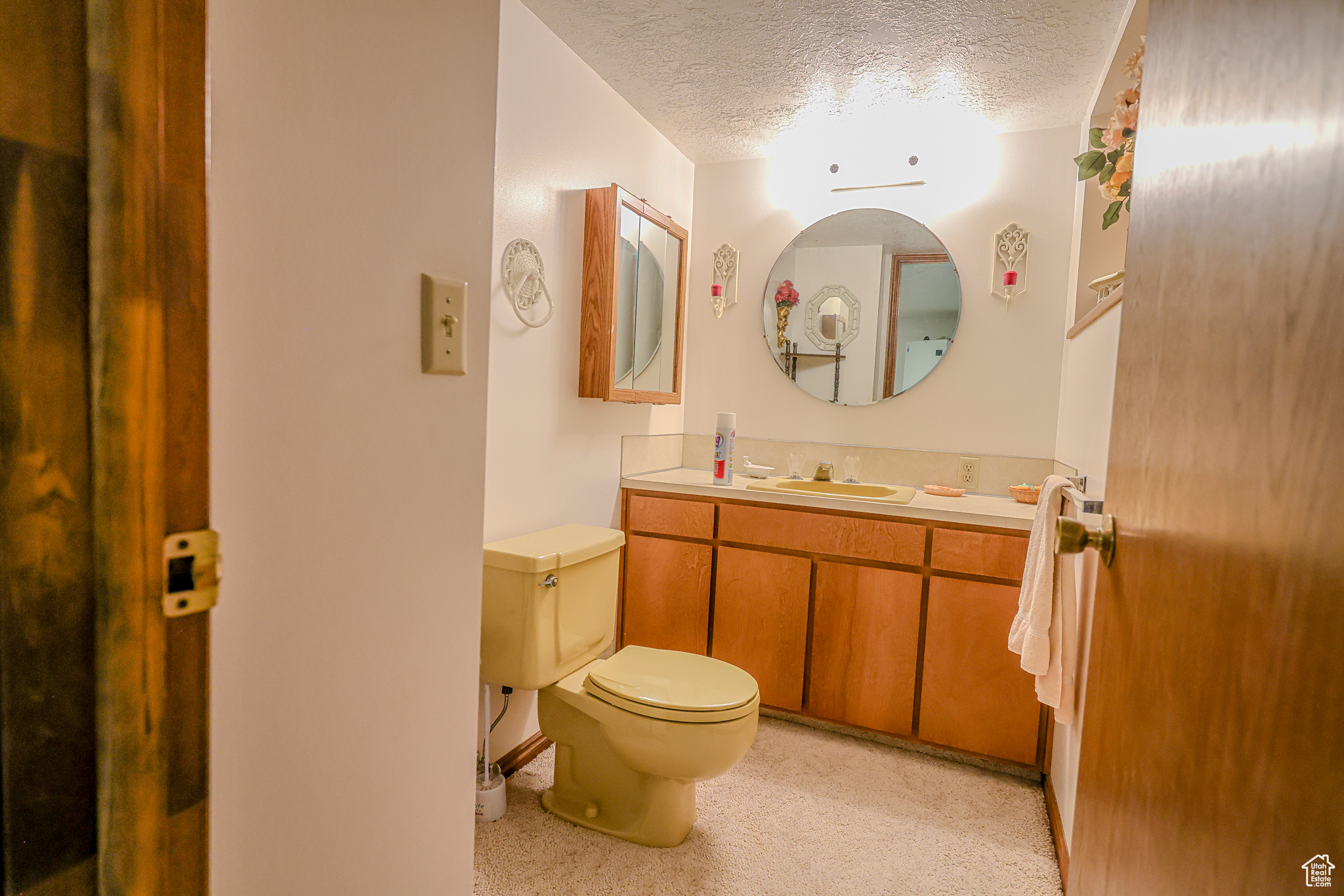 Bathroom with vanity, a textured ceiling, and toilet