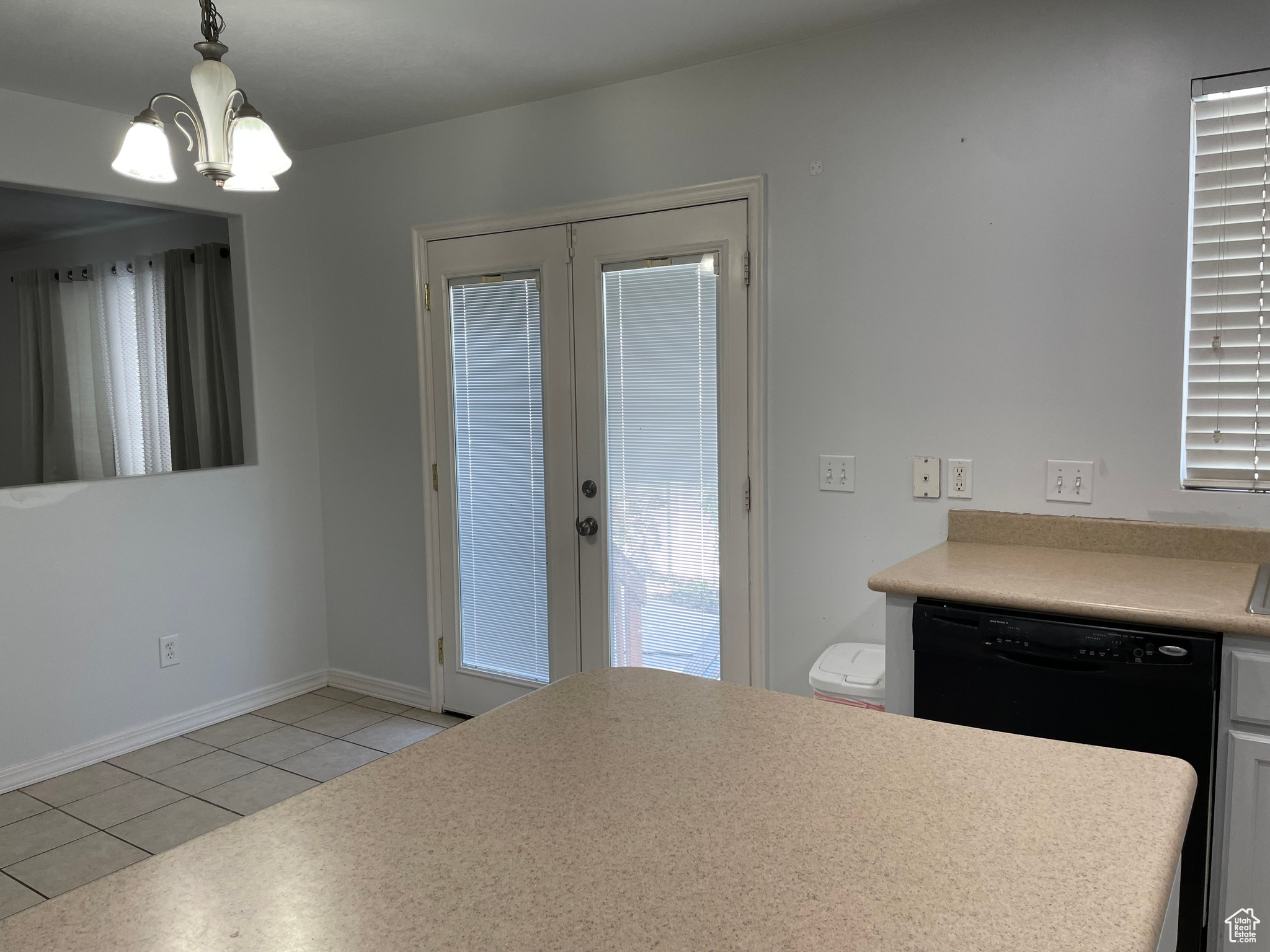 Kitchen featuring light tile patterned floors, a notable chandelier, and decorative light fixtures