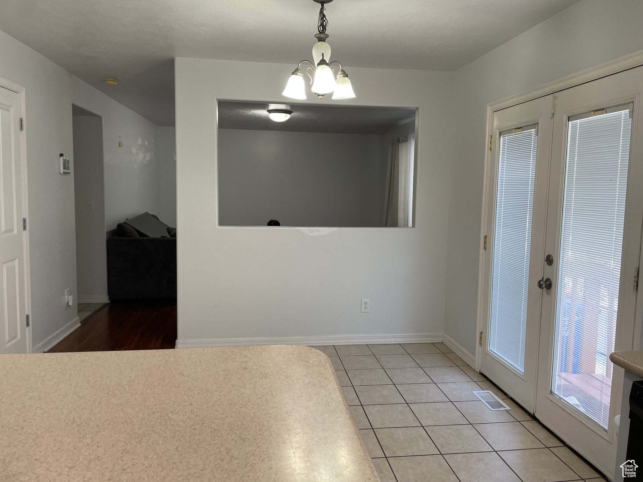 Interior space featuring french doors, a chandelier, and light tile patterned flooring