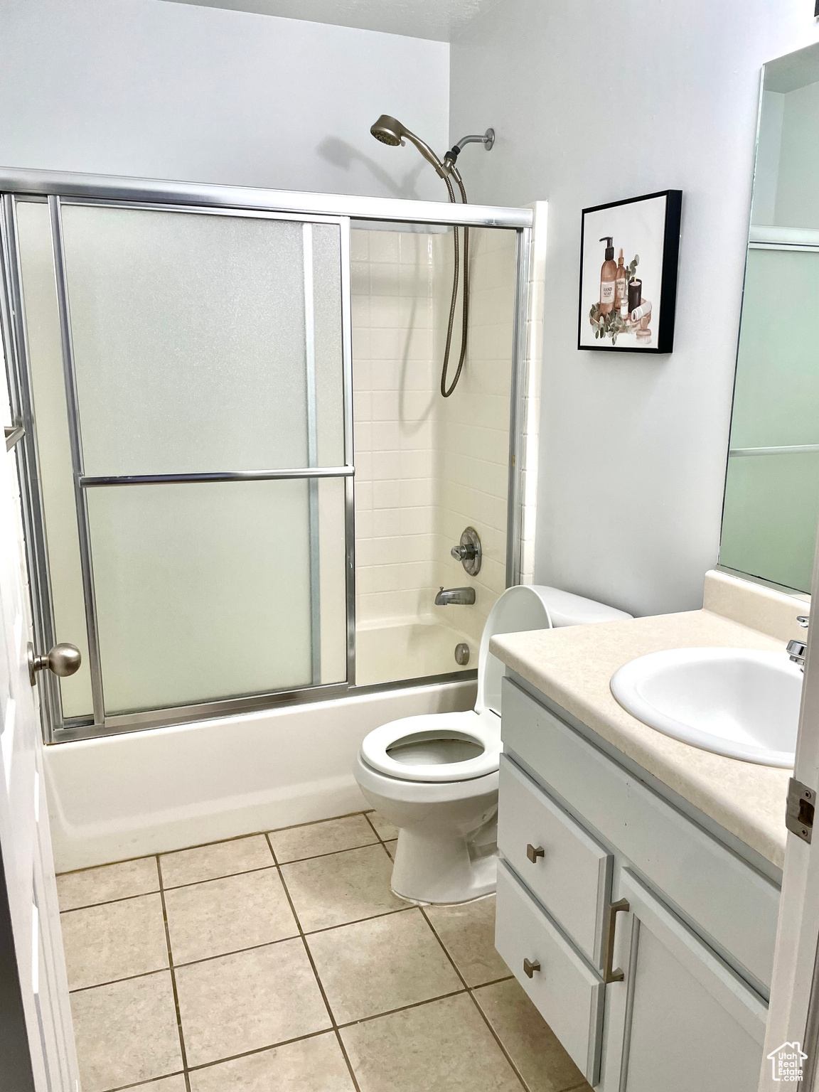 Full bathroom featuring shower / bath combination with glass door, vanity, toilet, and tile patterned flooring