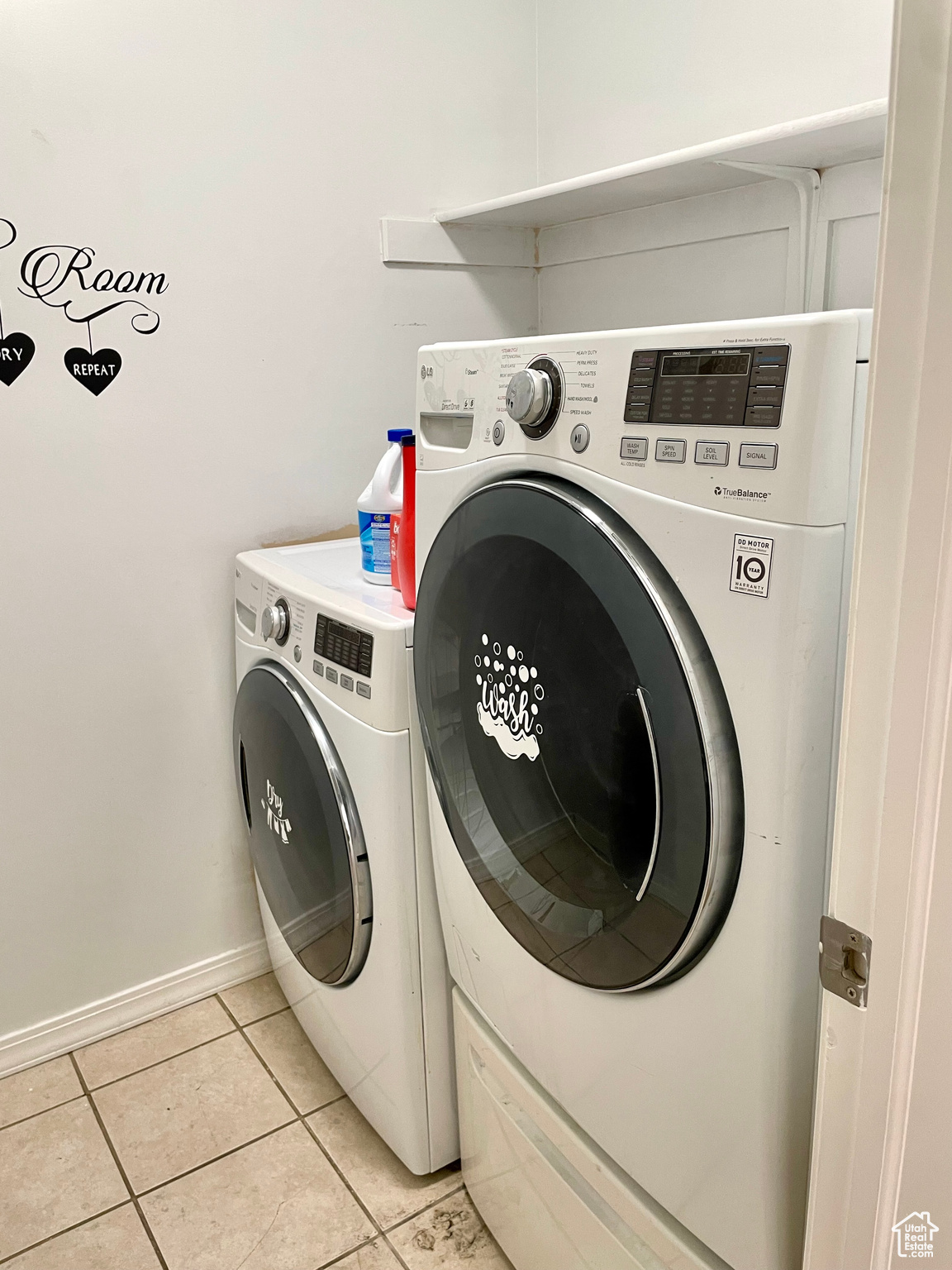 Laundry area featuring light tile patterned flooring and washing machine and dryer