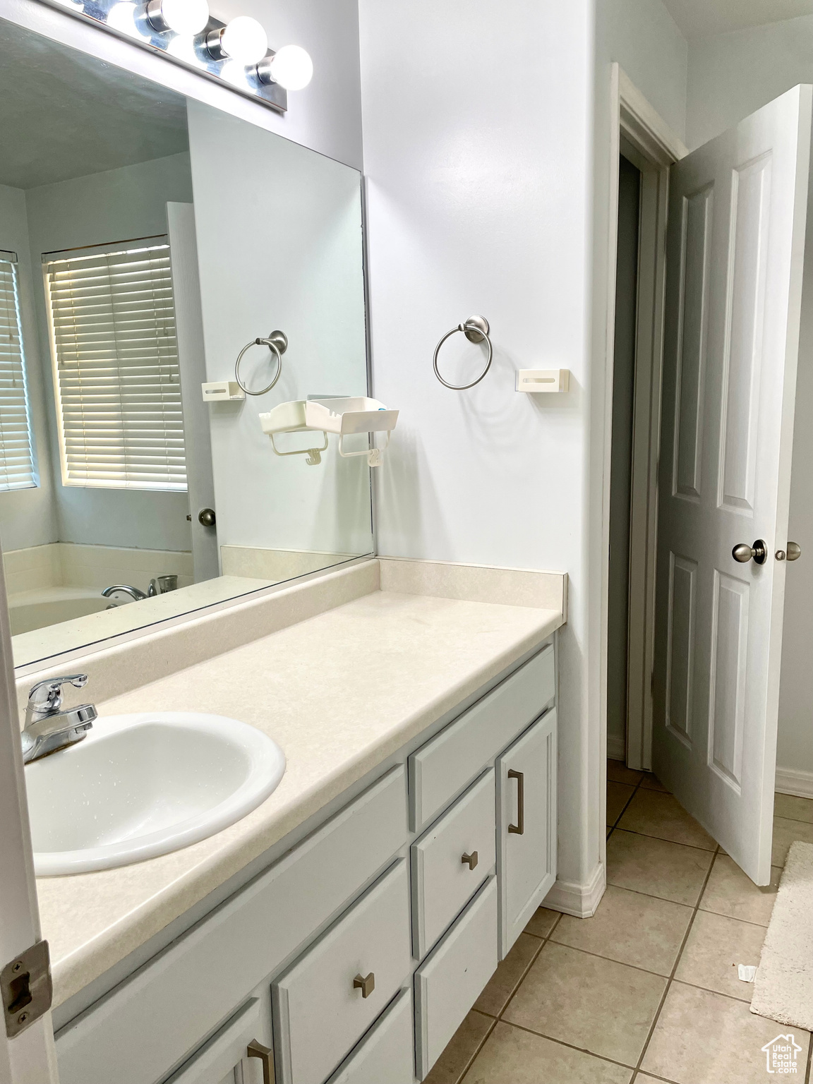 Bathroom featuring vanity, a bathing tub, and tile patterned floors